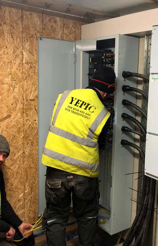 Yepic logo on back of high vis jacket, electrician working.