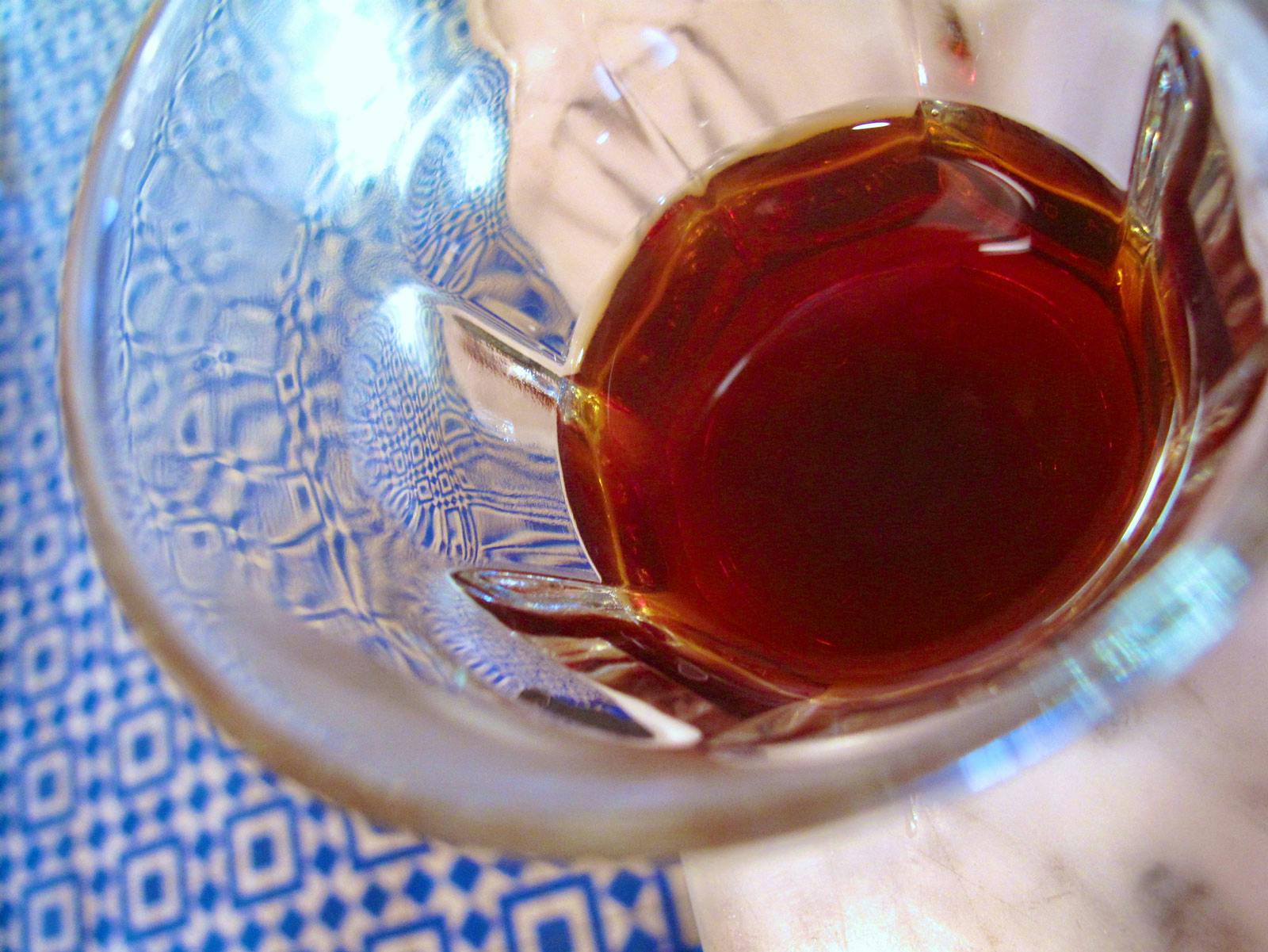 close up of a glass of brewed coffee above the blue and white floor tile of Intelligentsia Silver Lake