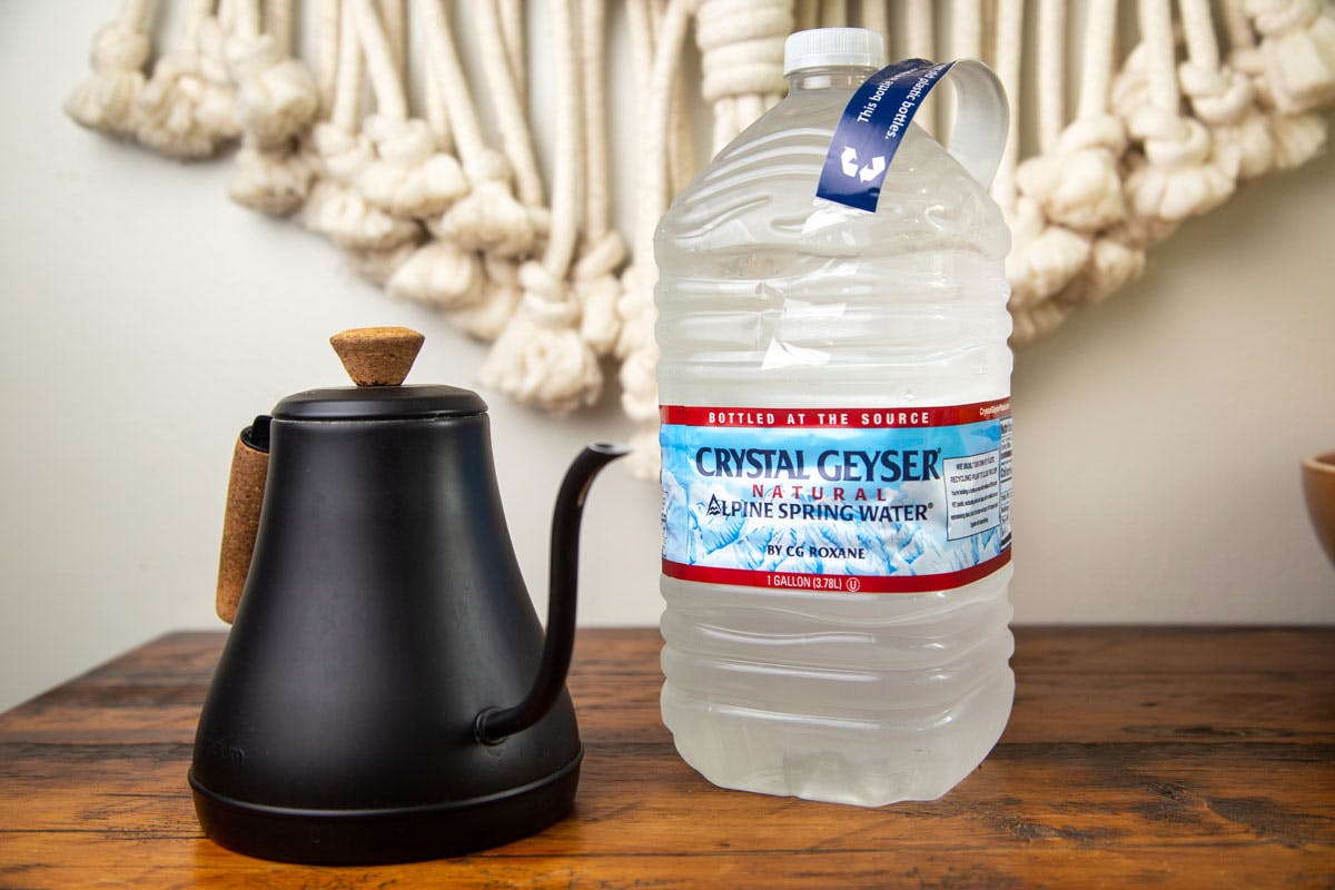 a bottle of Crystal Geyser water next to a Bodum gooseneck pouring kettle