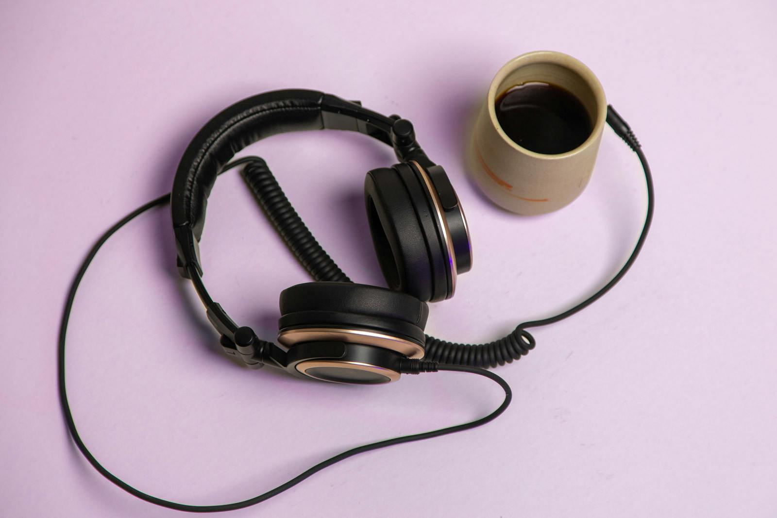 a cup of Yes Plz Coffee with headphones at the ready