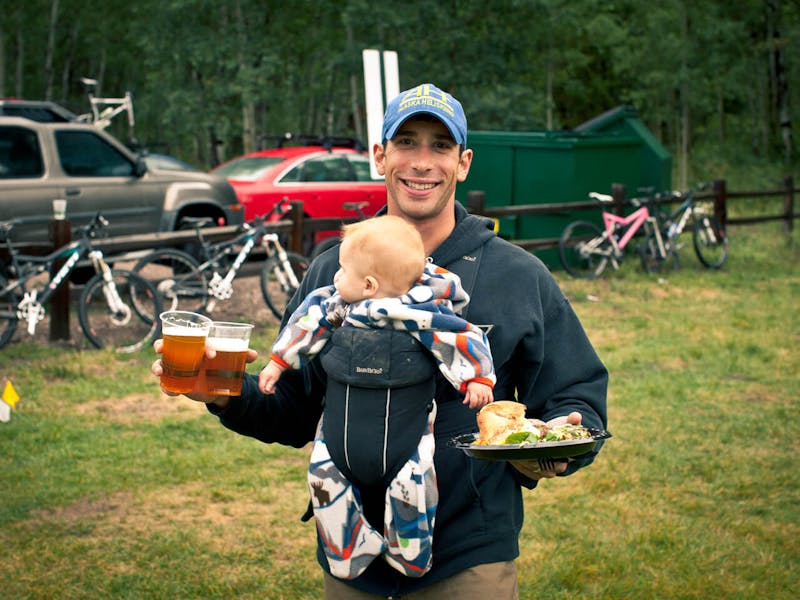 A dad with full hands after a day of riding