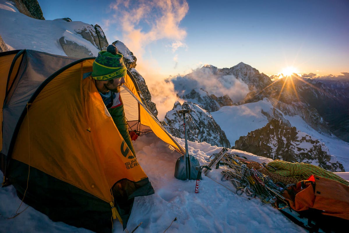 Renan Ozturk emerging from his tent at sunrise