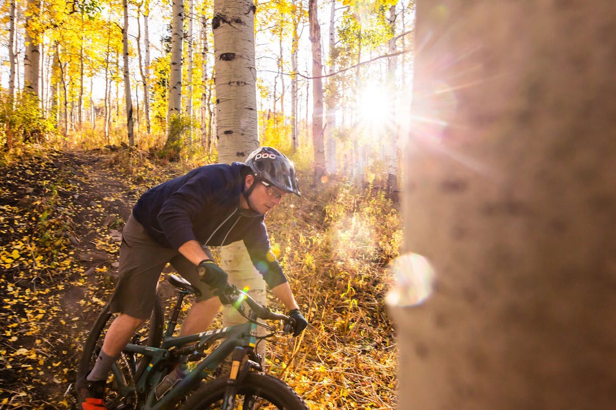 Jim Harris riding through aspen trees