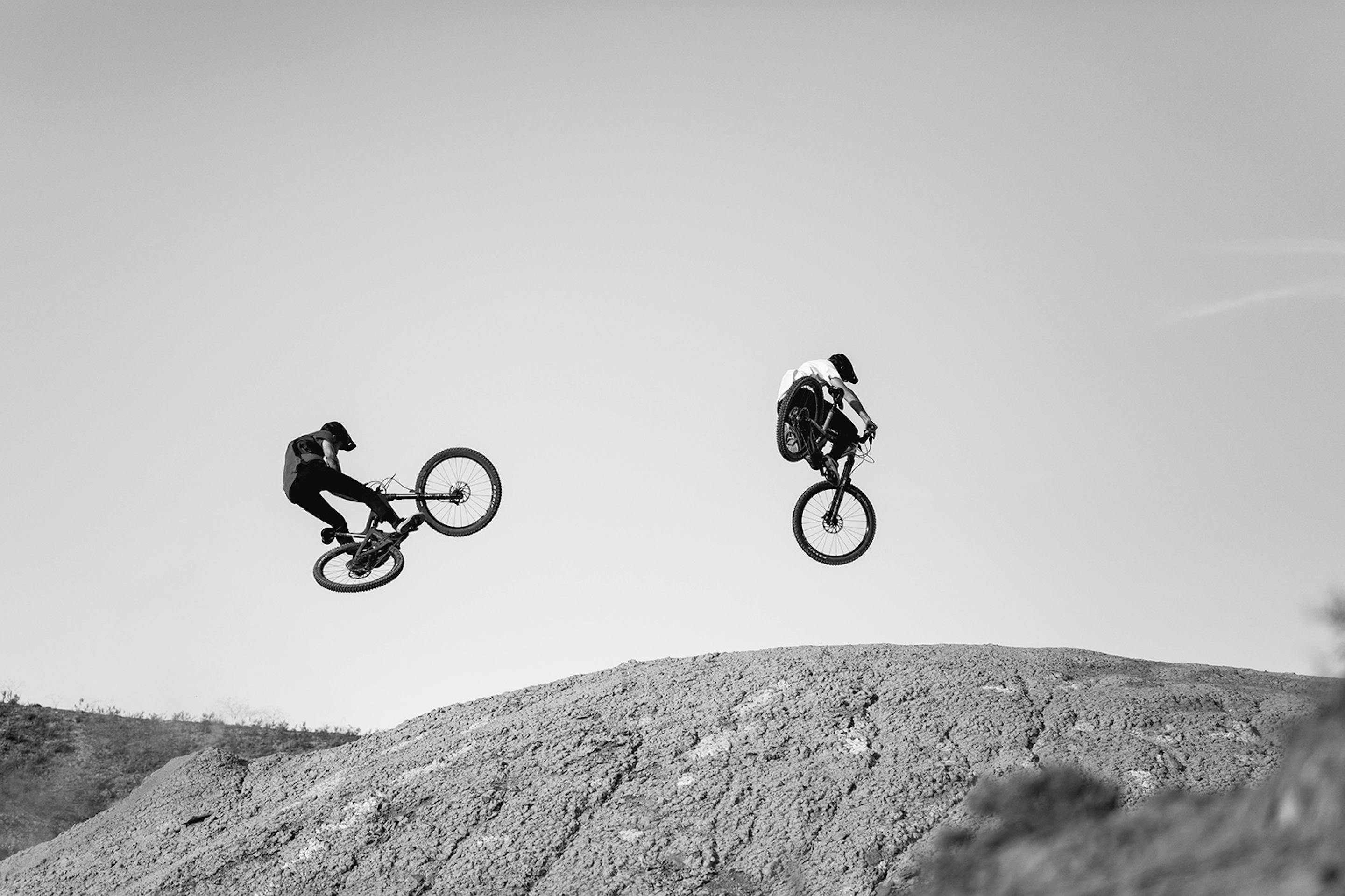 two riders jumping their trail bikes