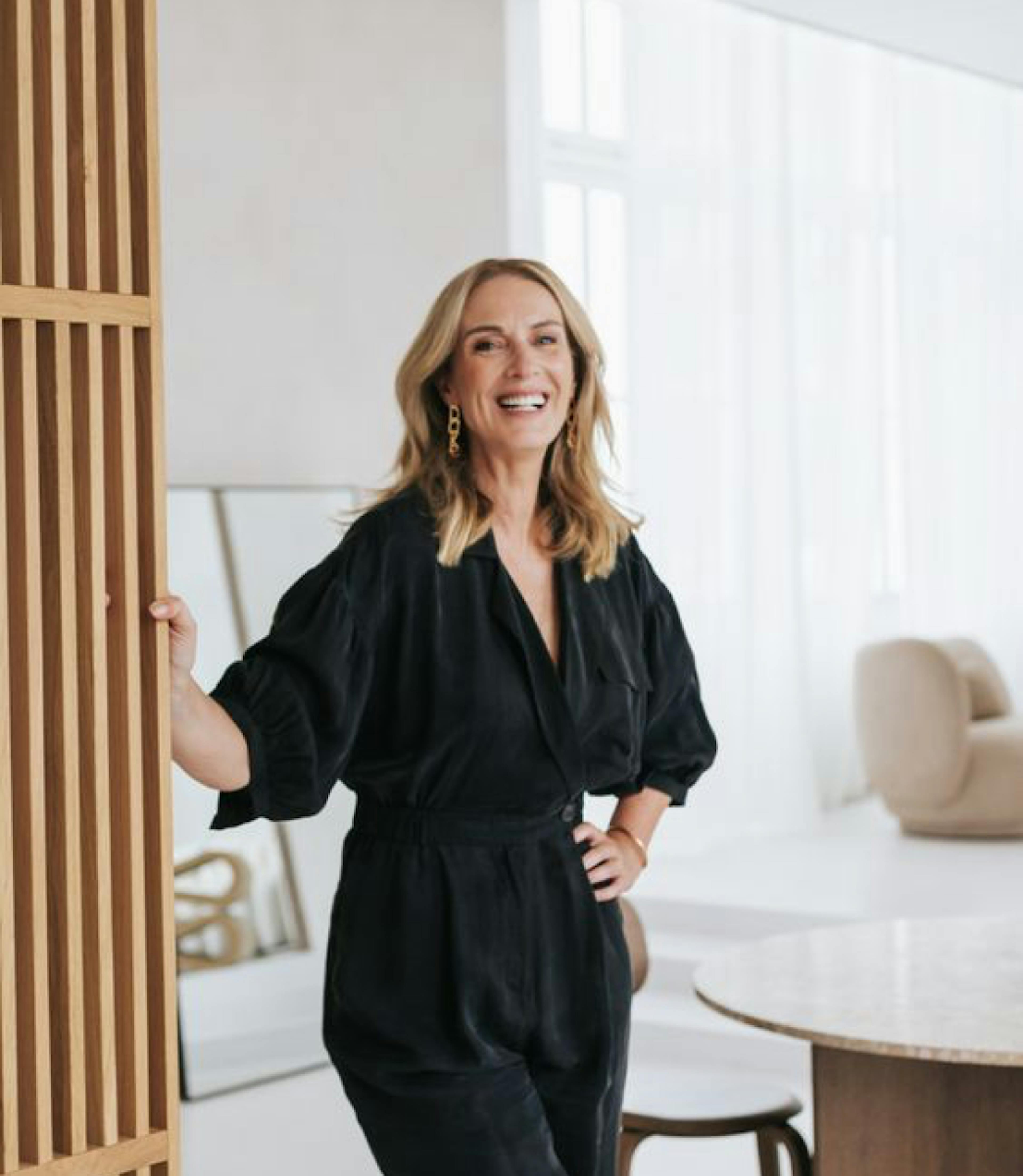 Woman leaning against a wall, smiling