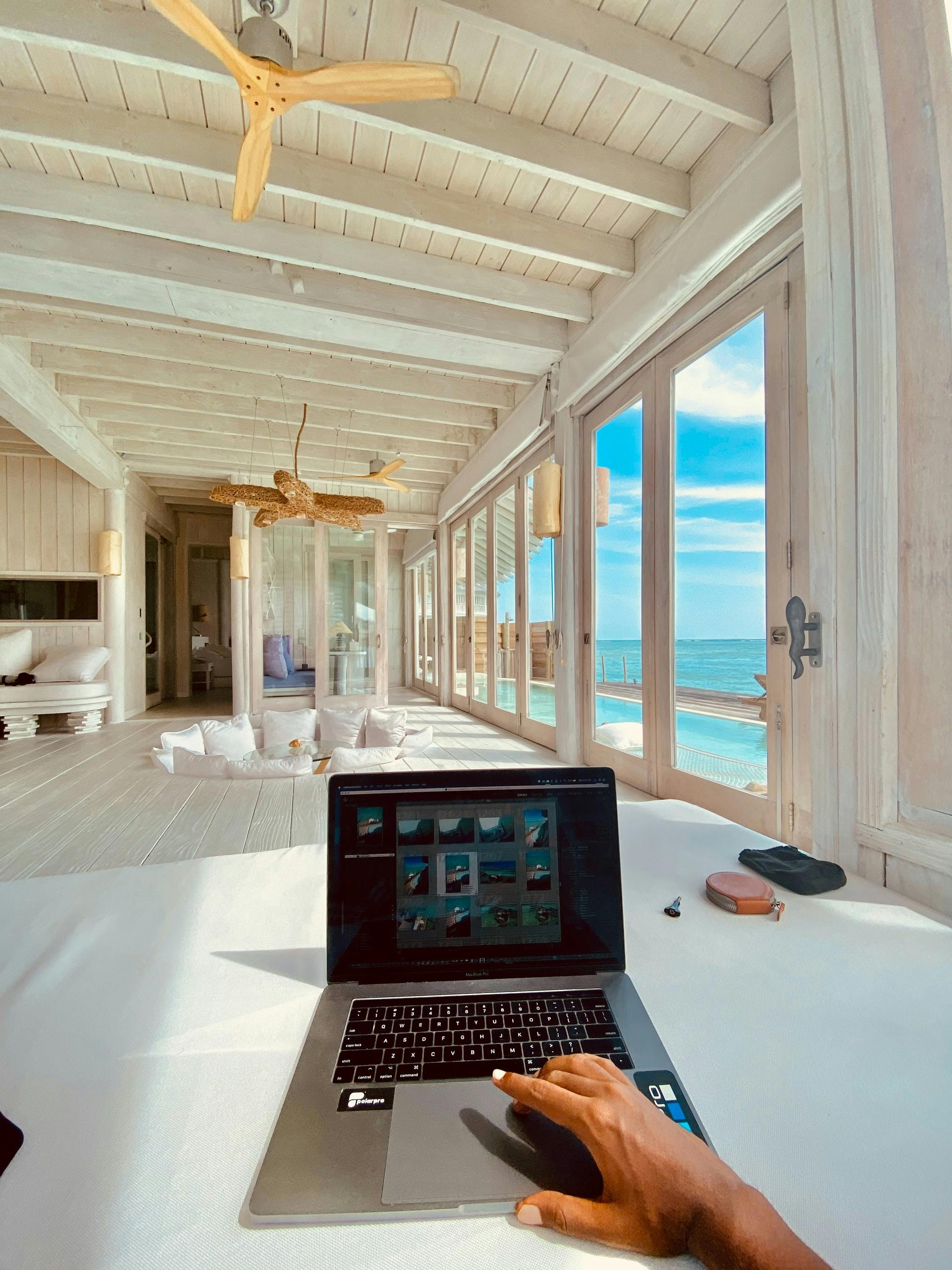Someone working on a computer with a beautiful sea view