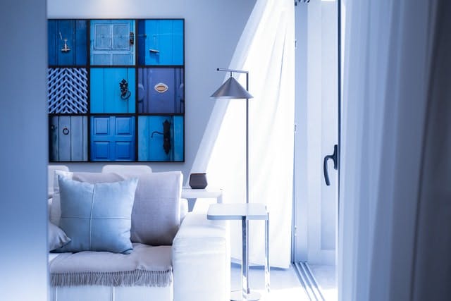 Modern living room, with blue bookshelf illuminated by natural light through sliding glass door. 