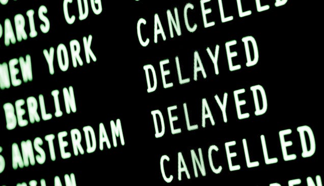 Display board at an airport showing delayed planes