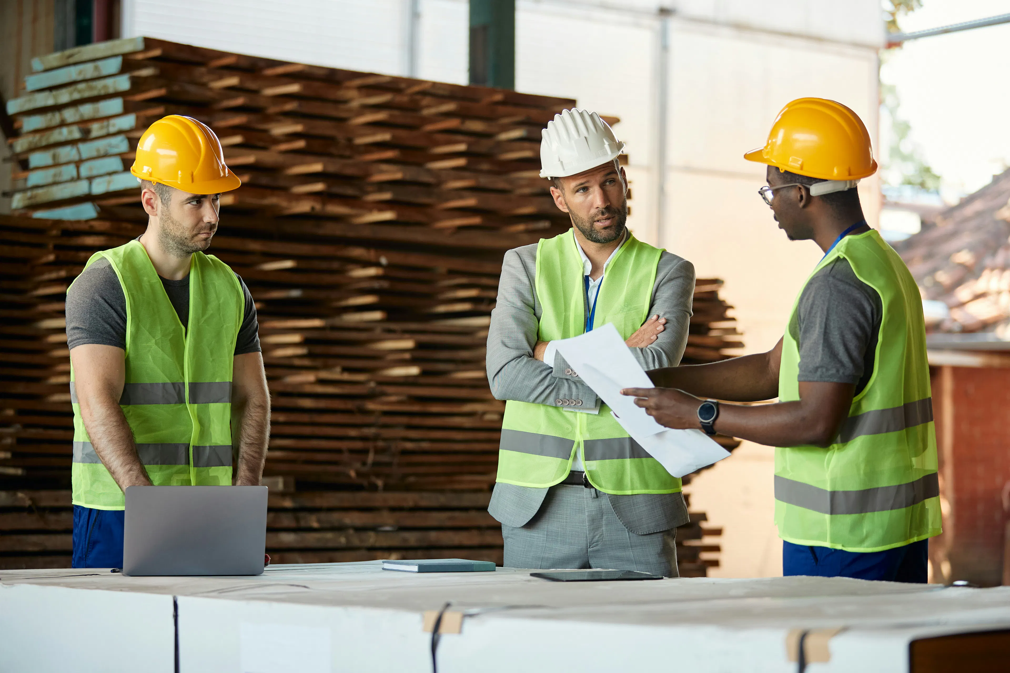 Workers in hard hats reviewing a document together.