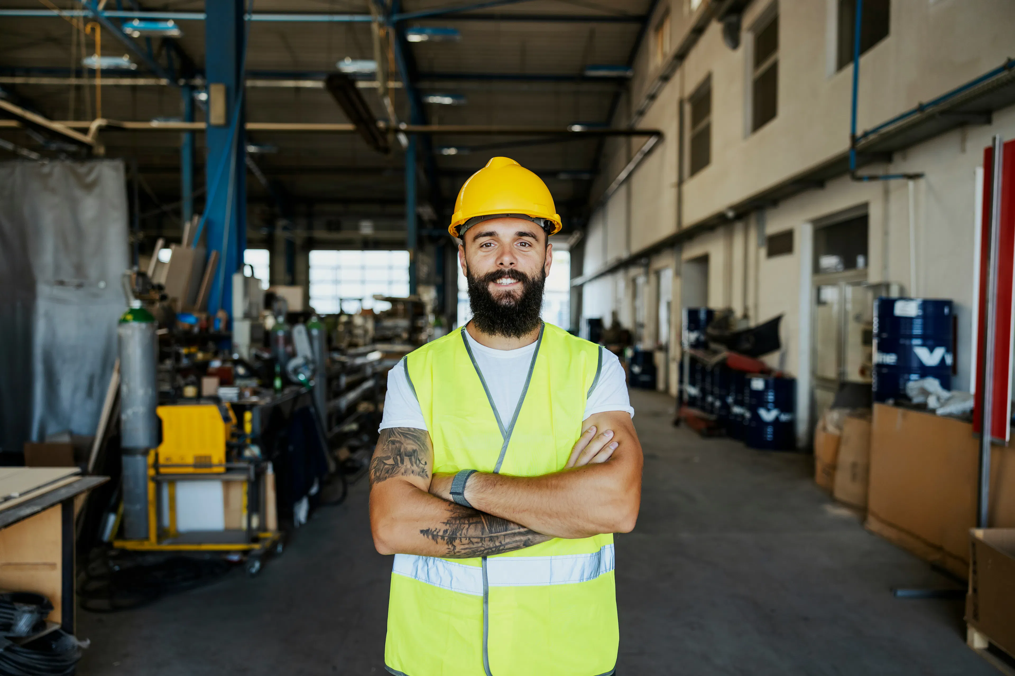 Worker in hard hat and safety vest inside industrial facility