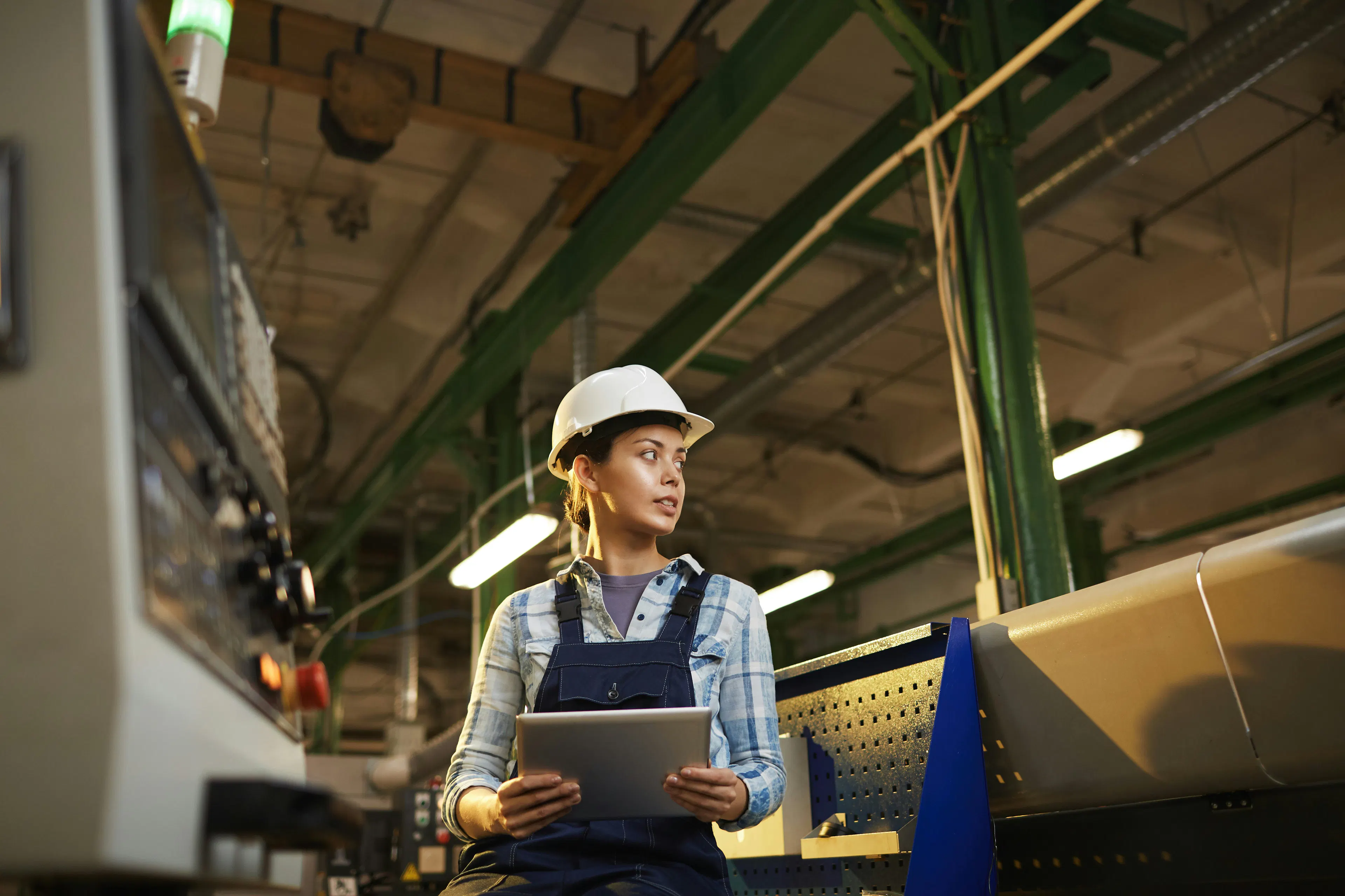 Factory worker pointing out a machine hazard to a coworker.