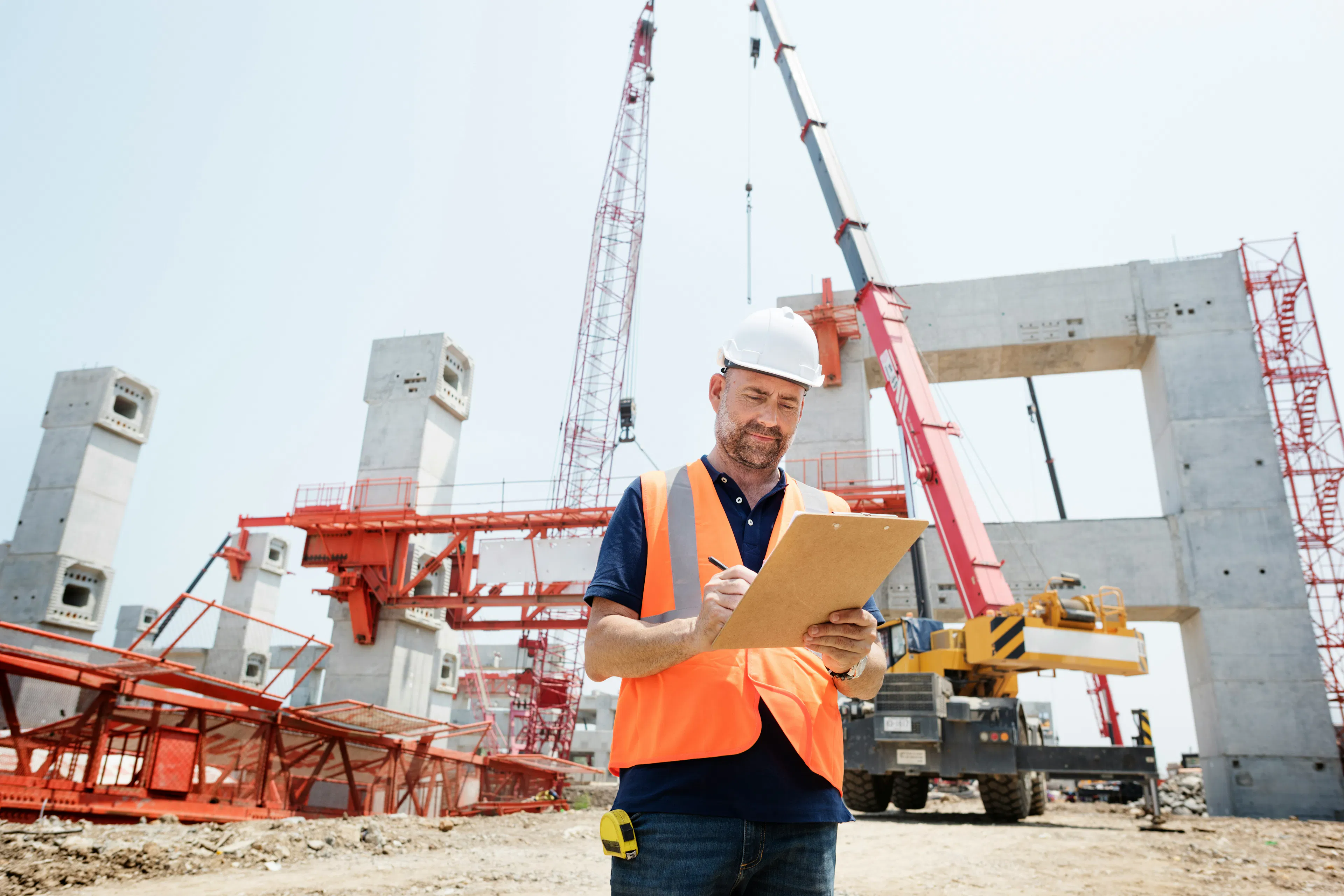Site supervisor with a clipboard on a construction site.