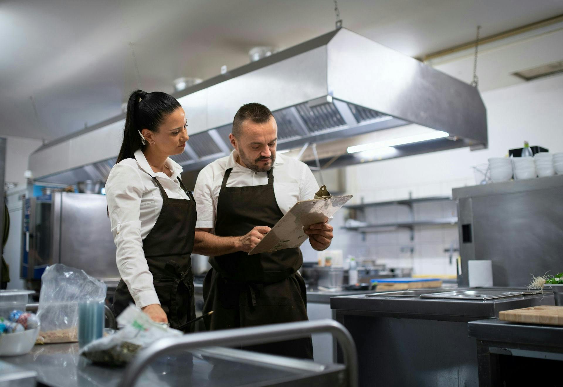 two chefs looking at the notes