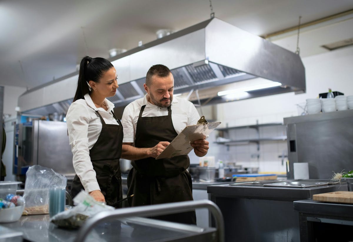 two chefs looking at the notes