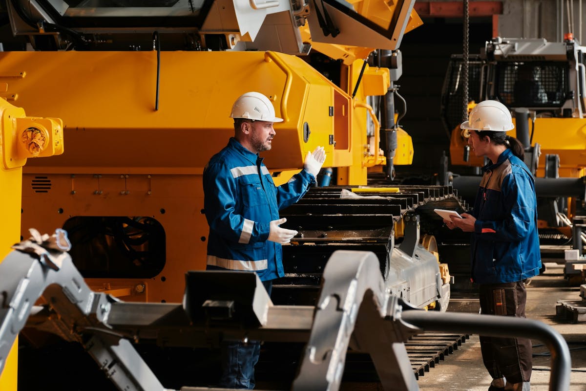 workers talking next to the machinery