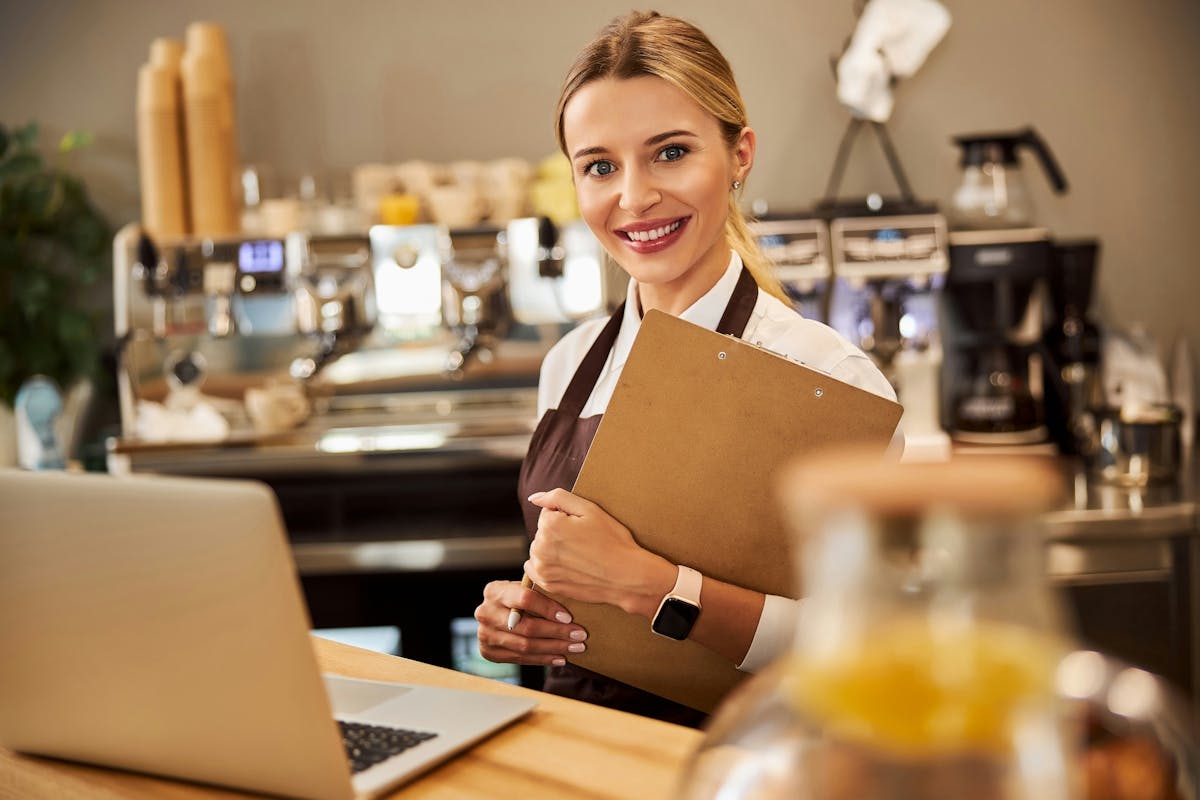 waiter holding a notebook and smiling