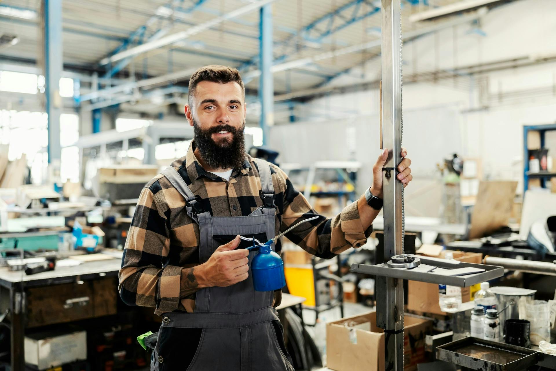 man holding blue metal oiler