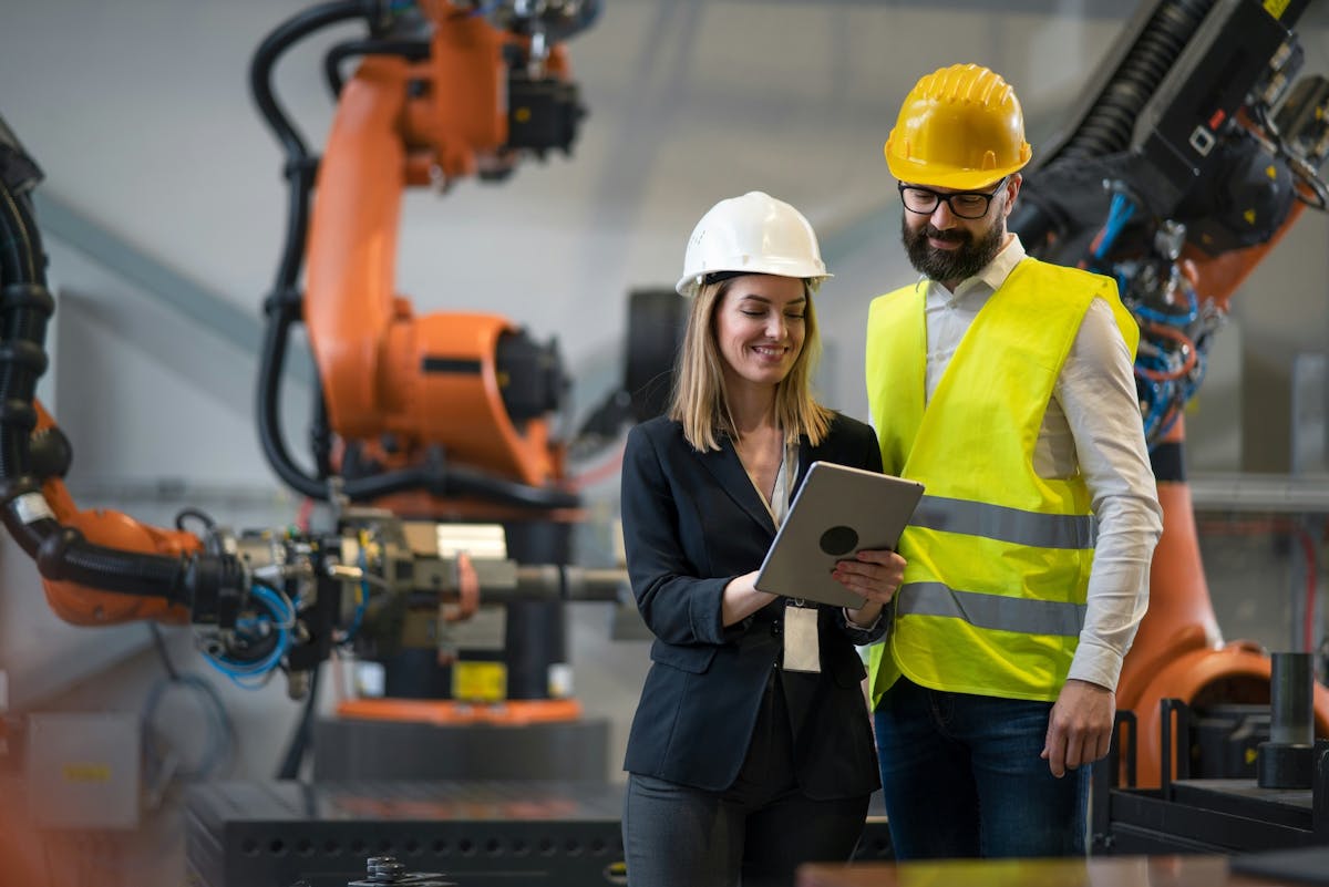 two workers looking at the tablet and smiling
