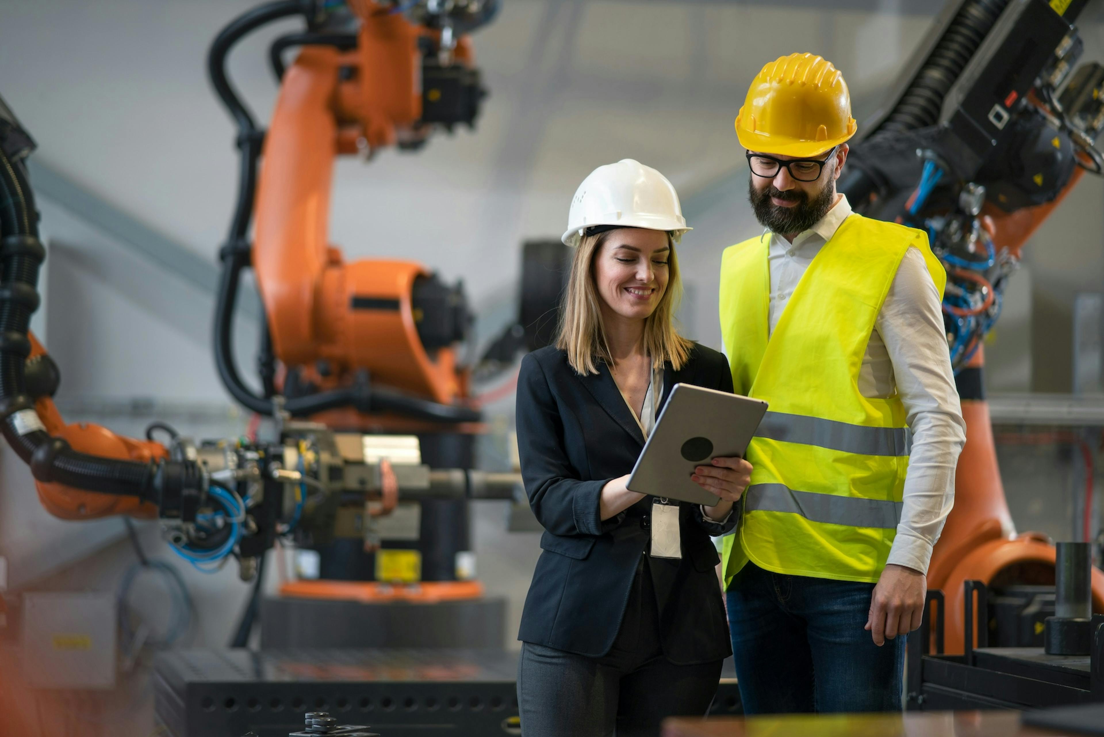 two workers looking at the tablet and smiling