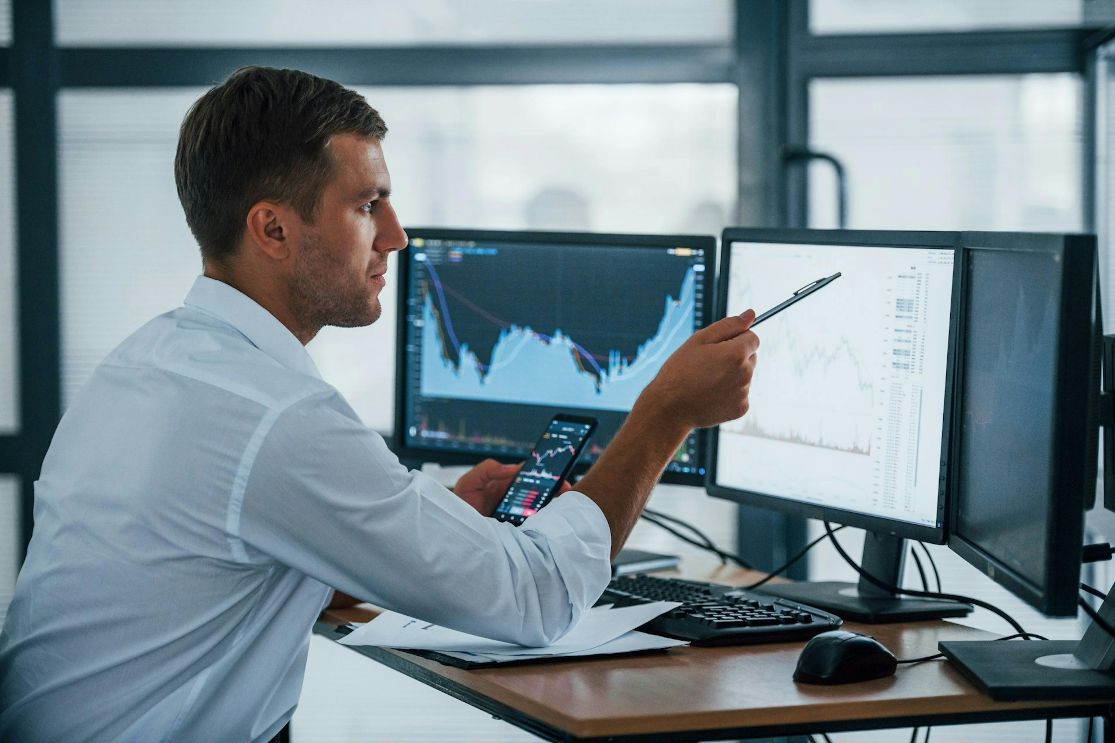 man in front of three screens with data displays