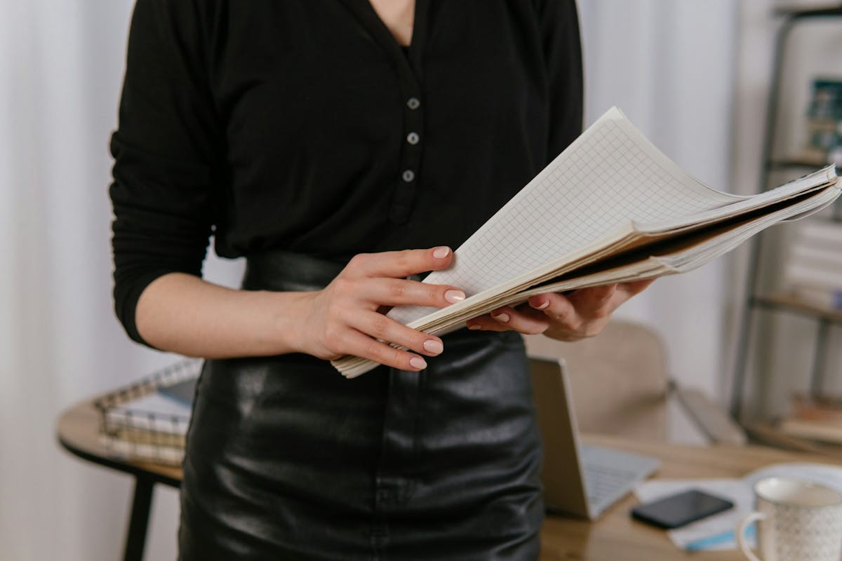 a woman in a black shirt holding documents