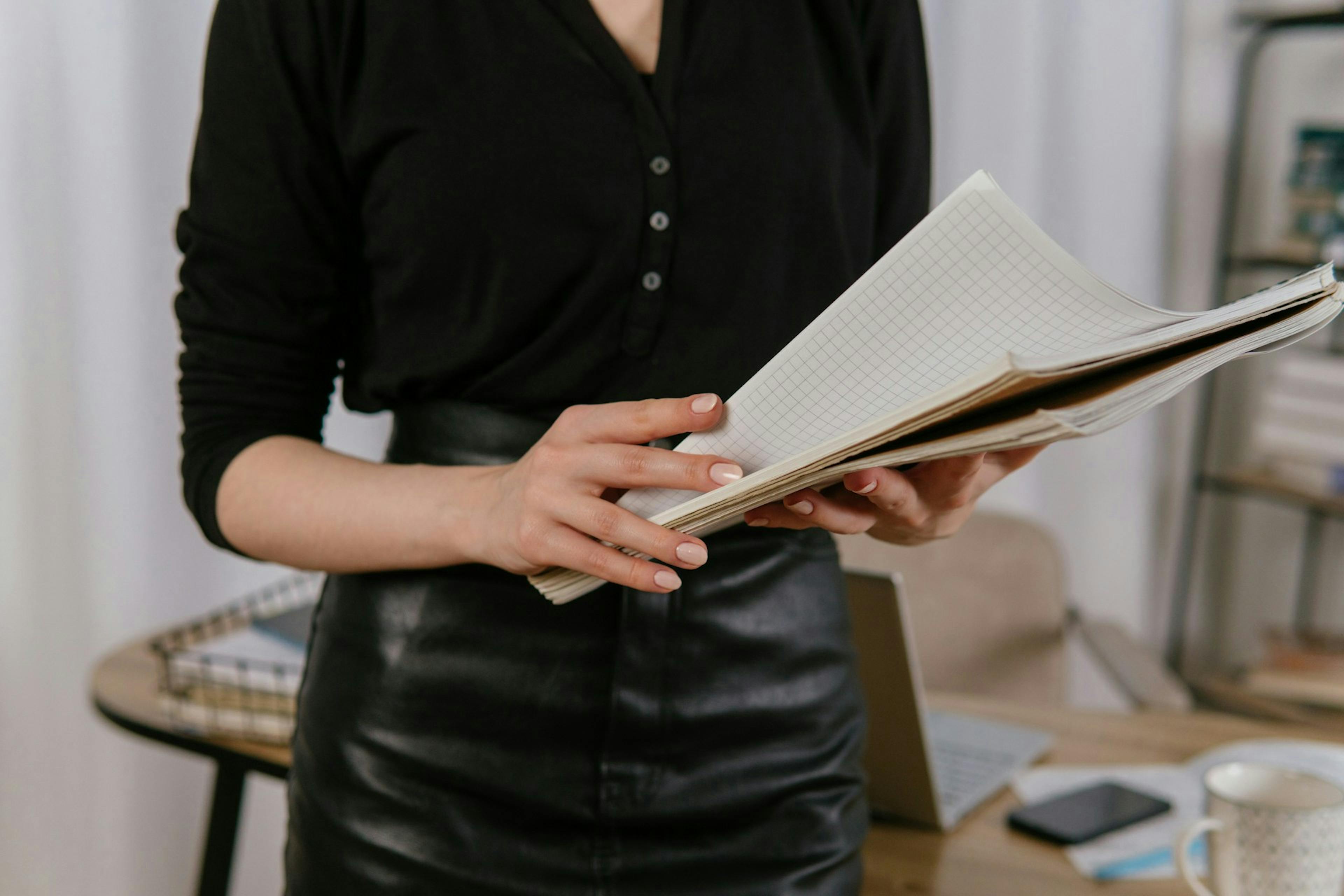 a woman in a black shirt holding documents