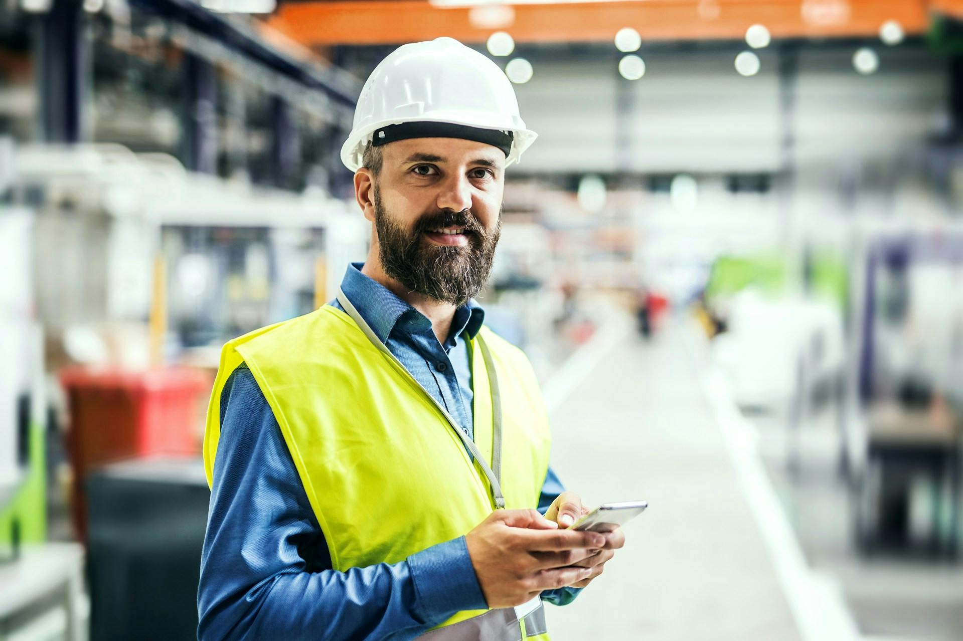 worker in a factory holding a phone