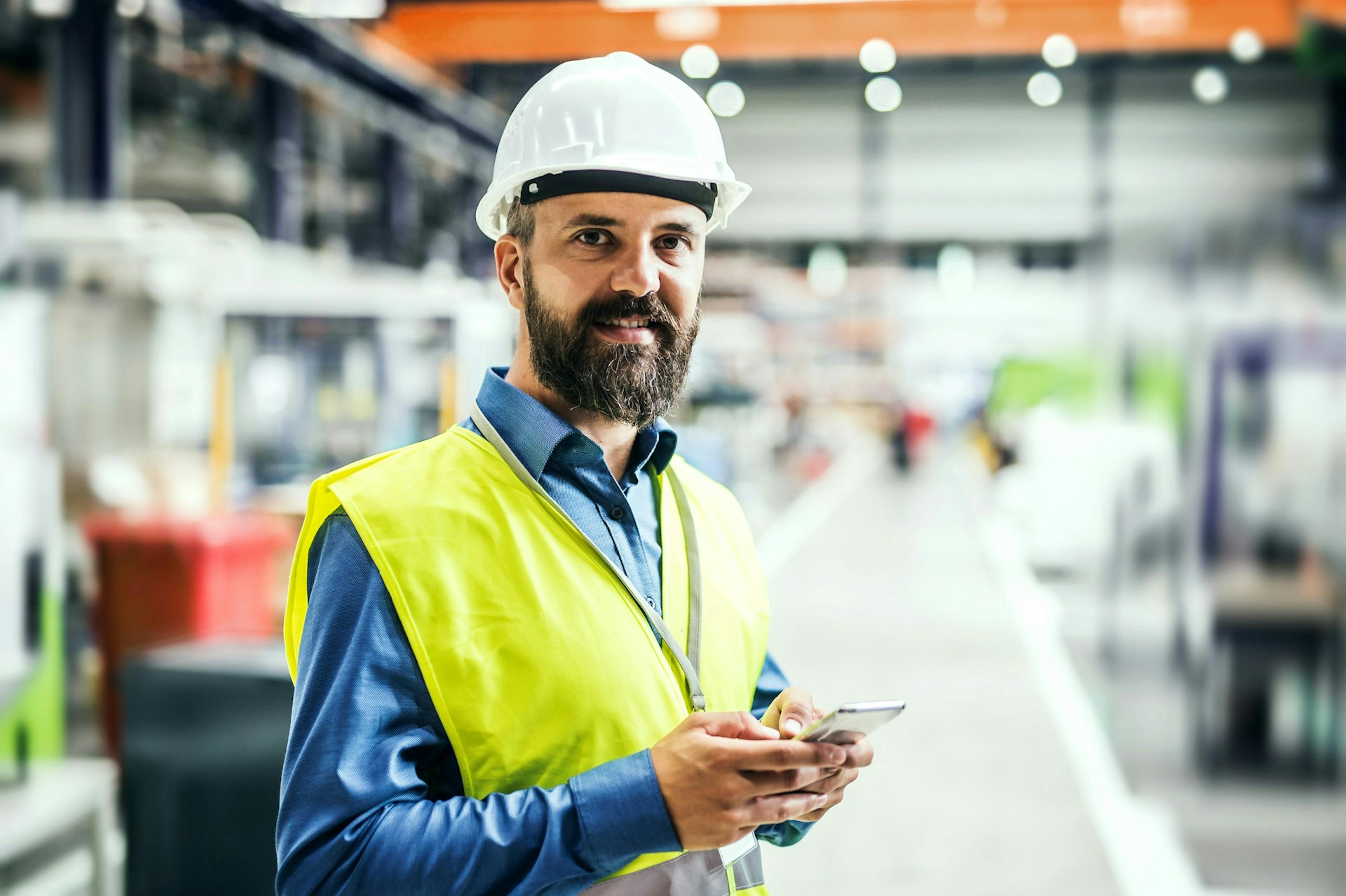 worker in a factory holding a phone