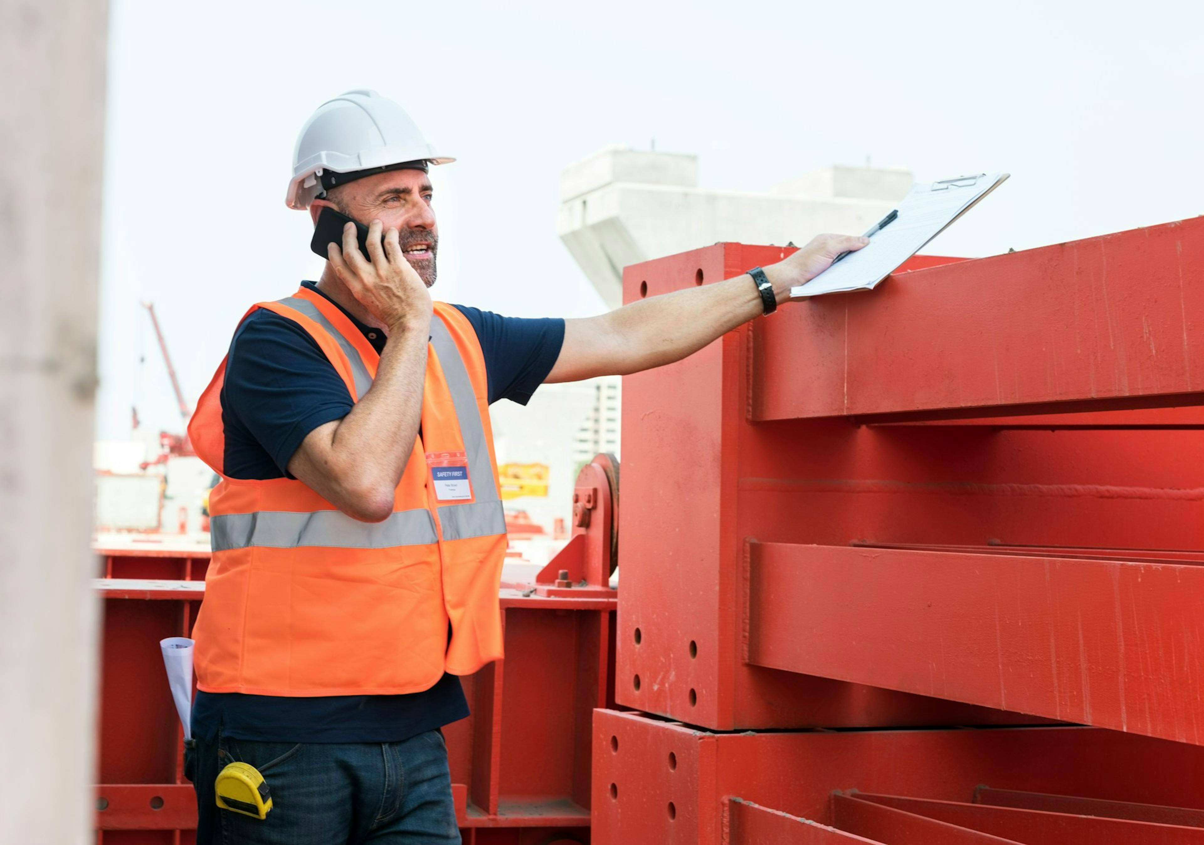 Worker talking on a phone holding a notebook