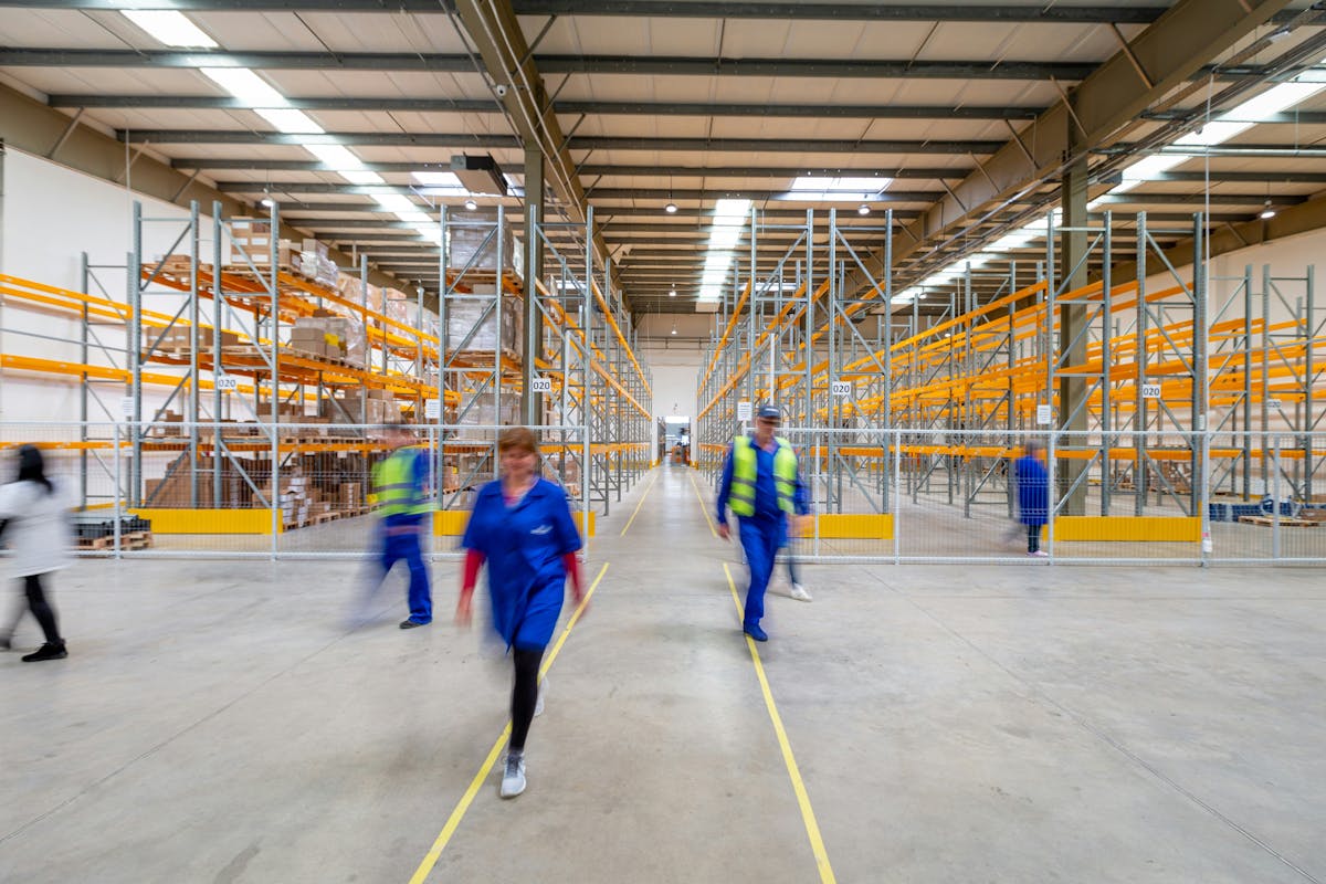 Warehouse workers moving through a large distribution facility