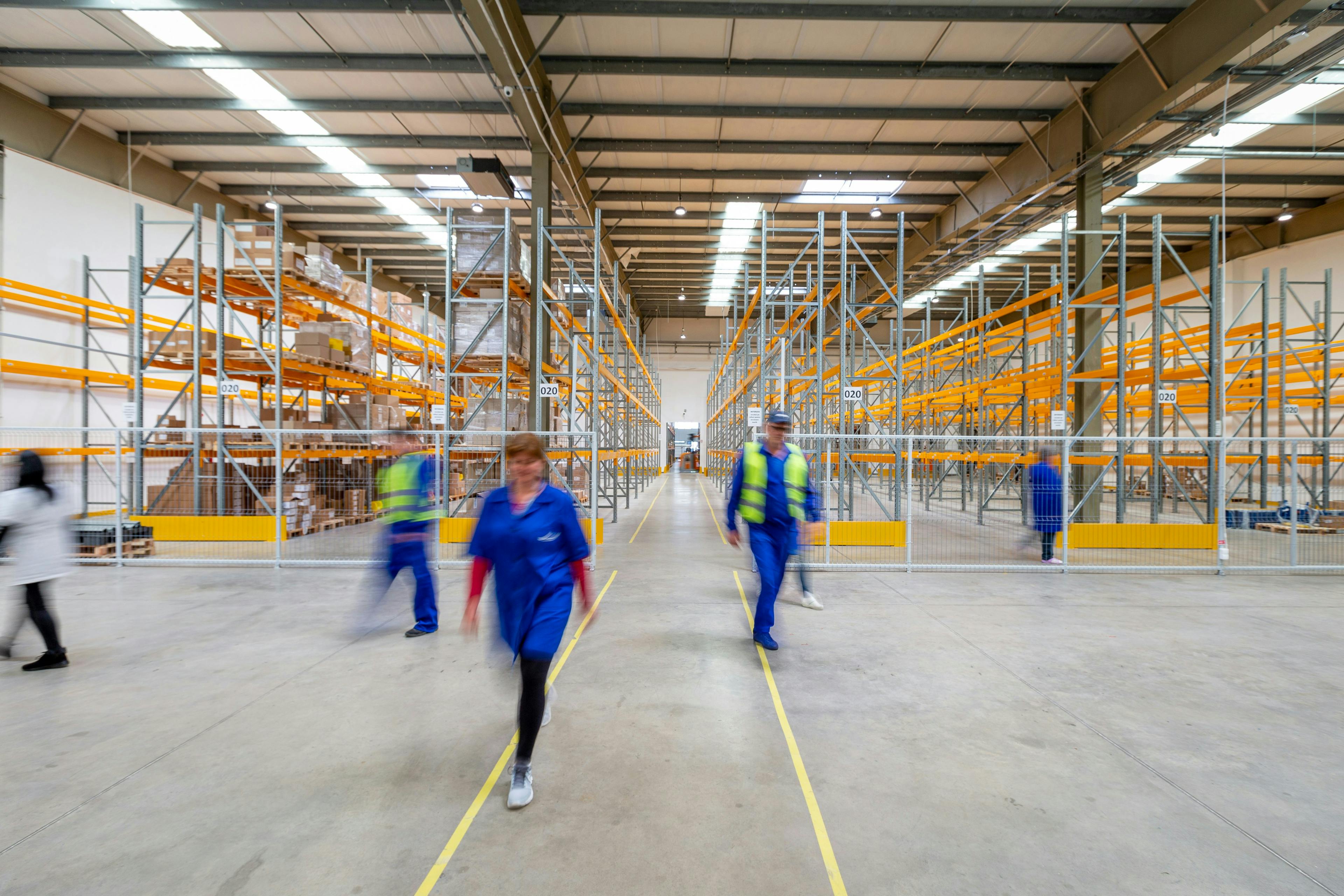 Warehouse workers moving through a large distribution facility