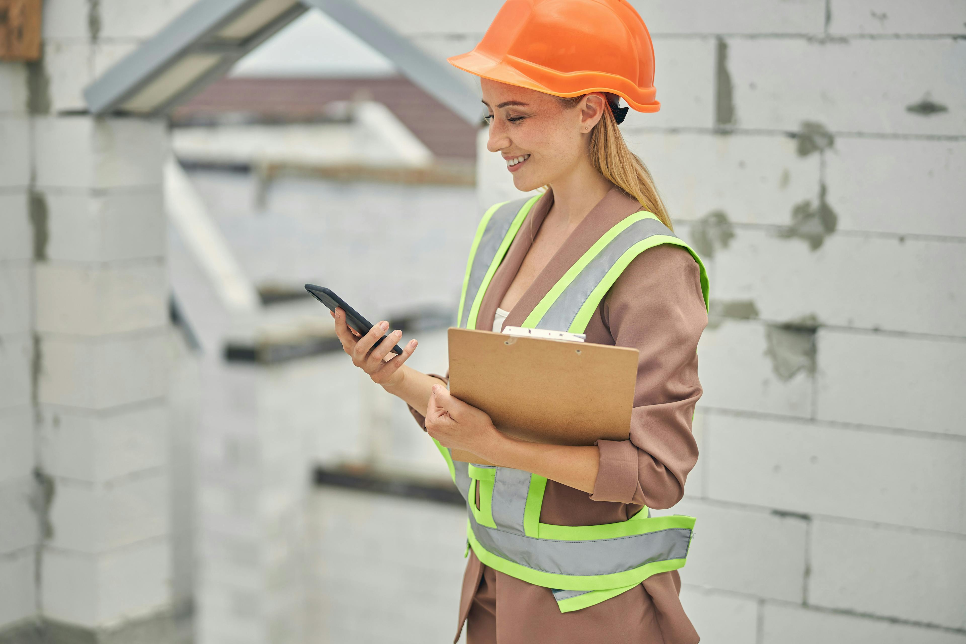 Construction manager checking phone on site