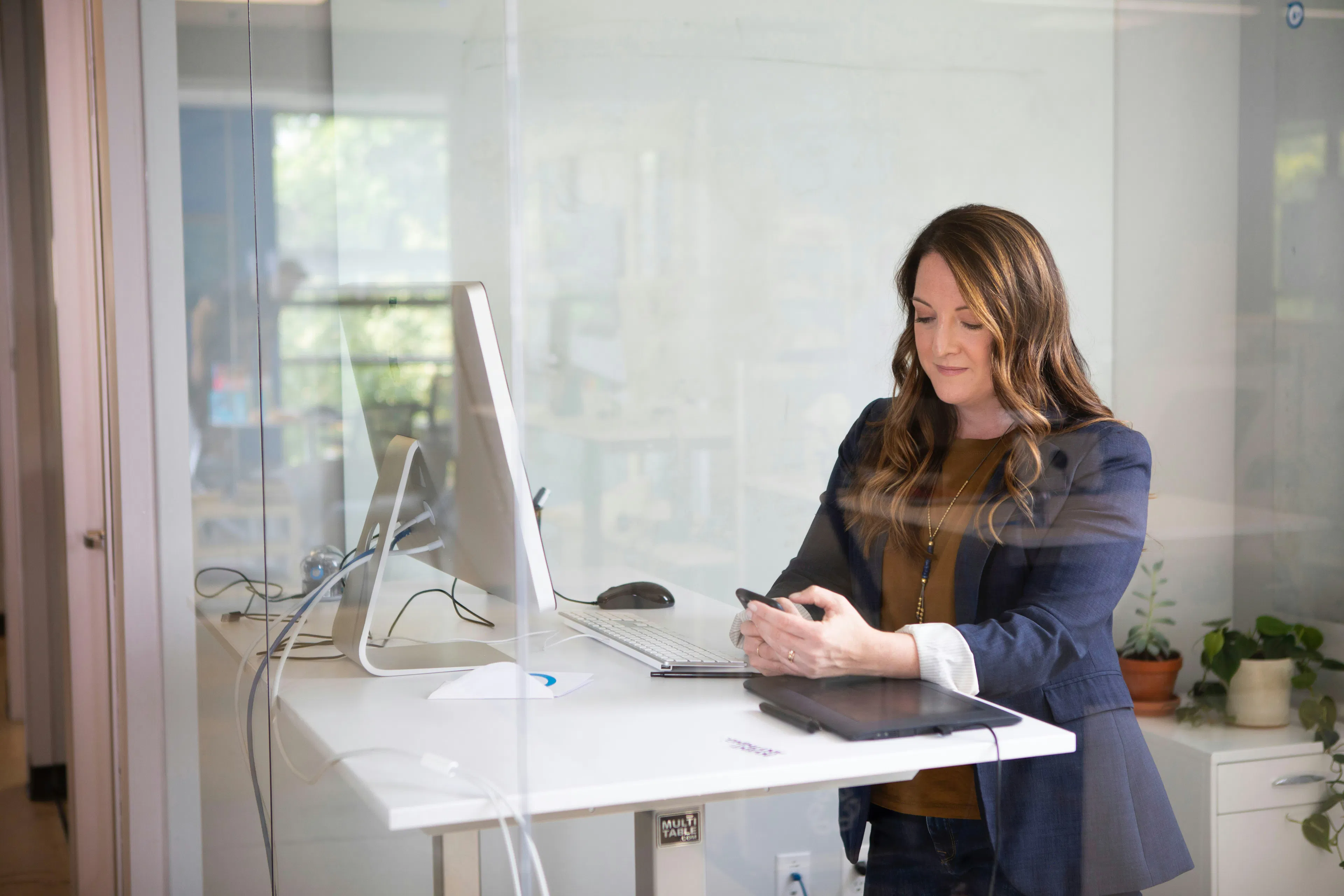 HR professional checking phone at standing desk