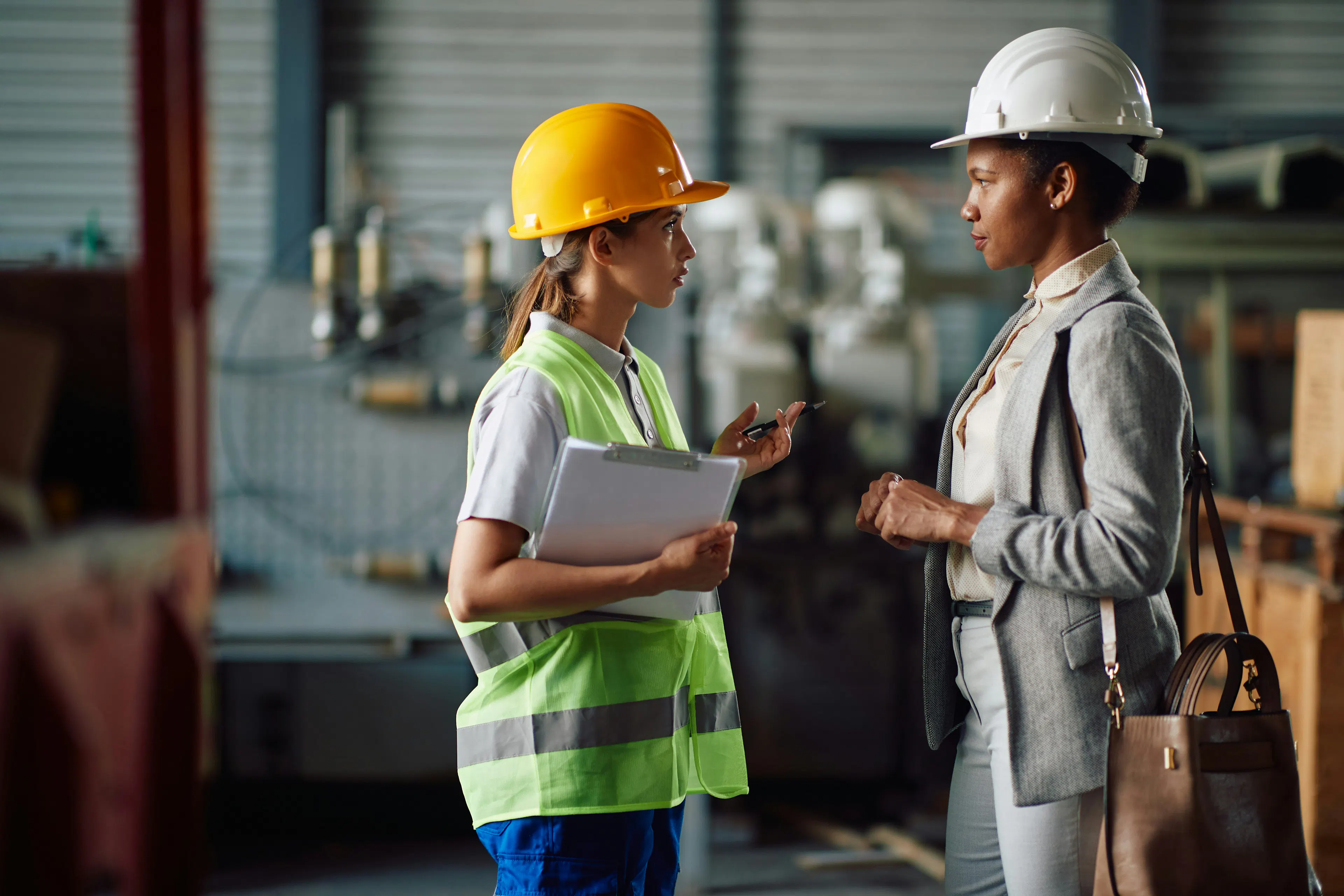 Supervisor and worker in conversation on industrial floor