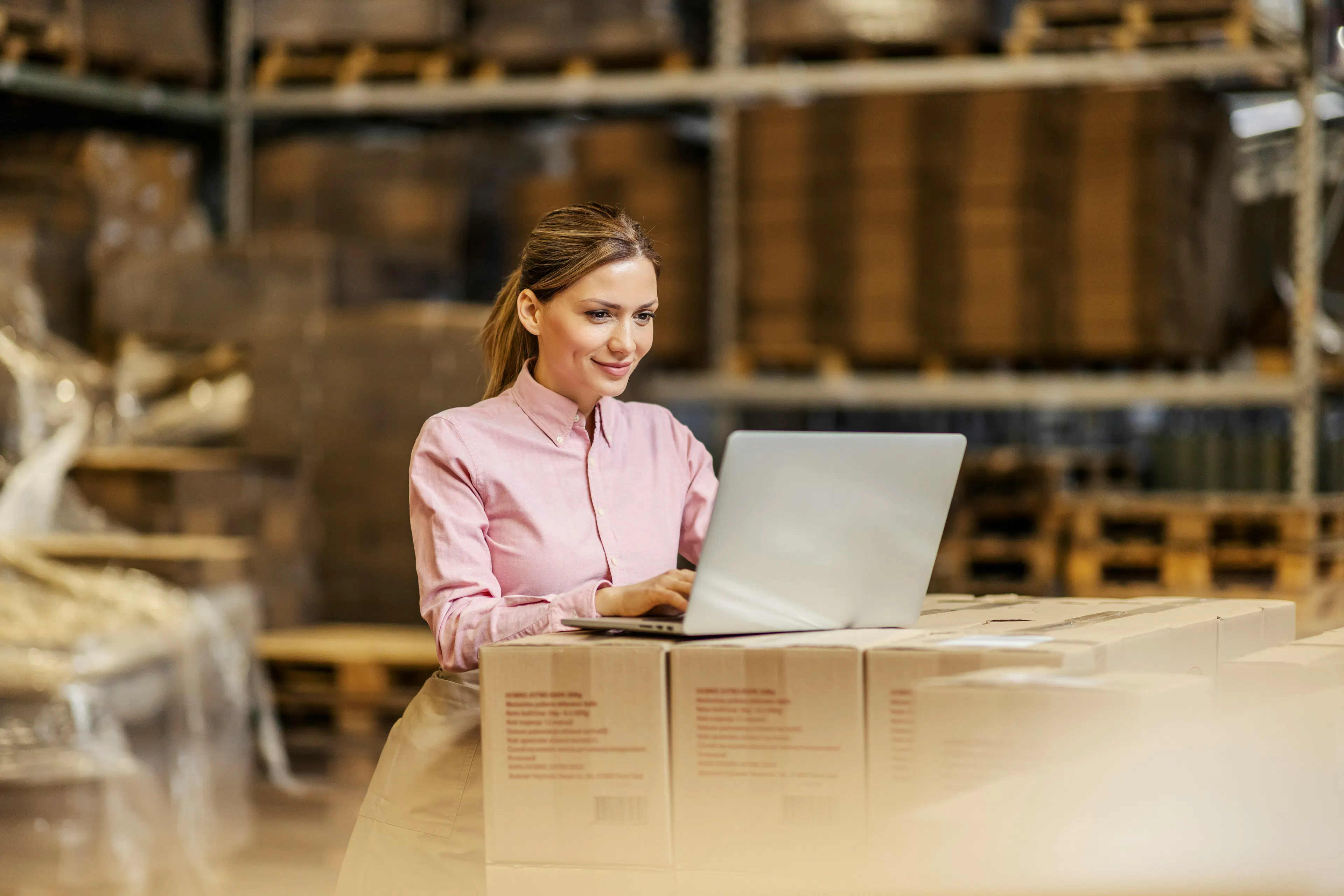 HR professional working on laptop in warehouse setting