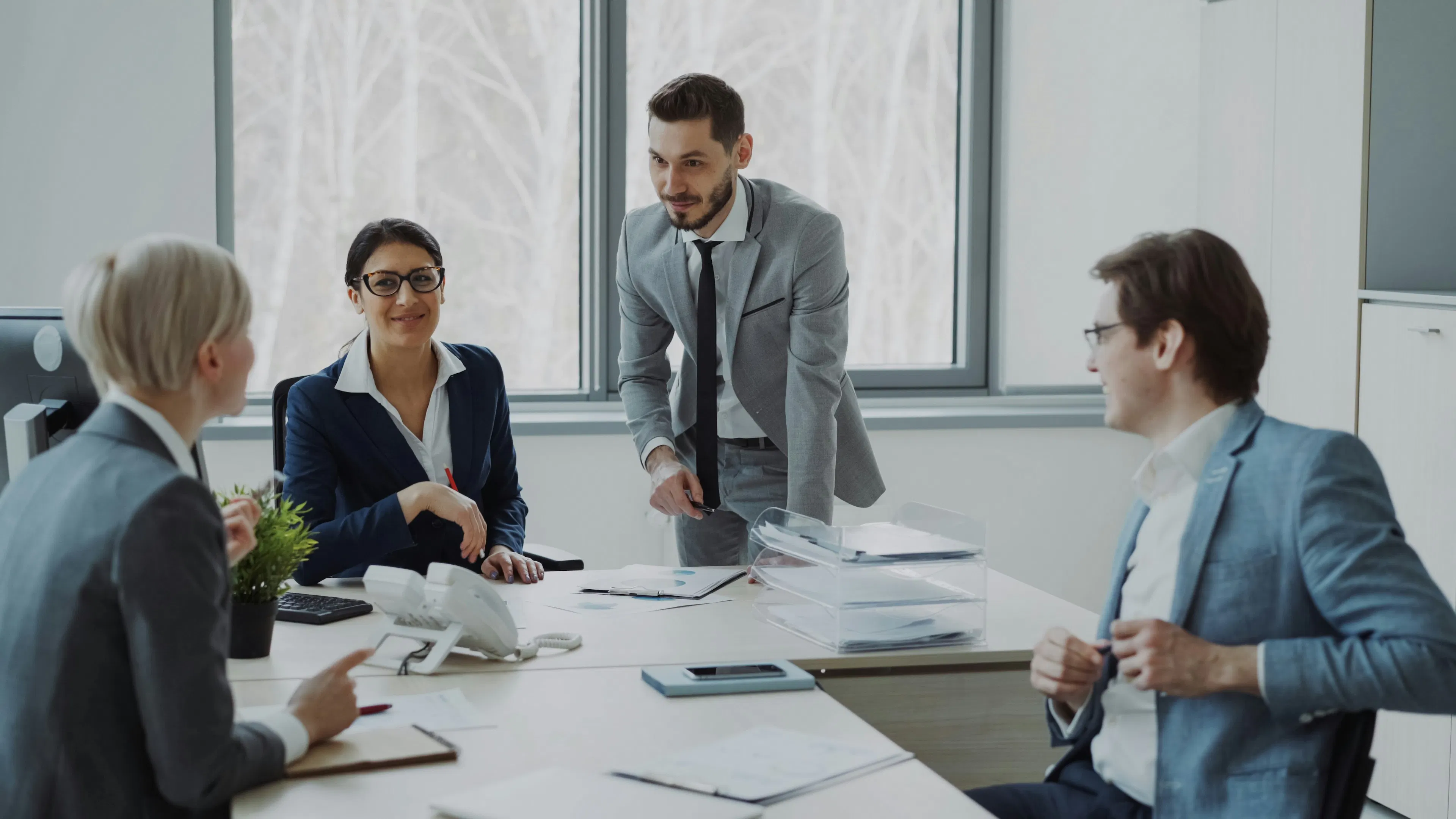 Business team meeting around conference table with documents