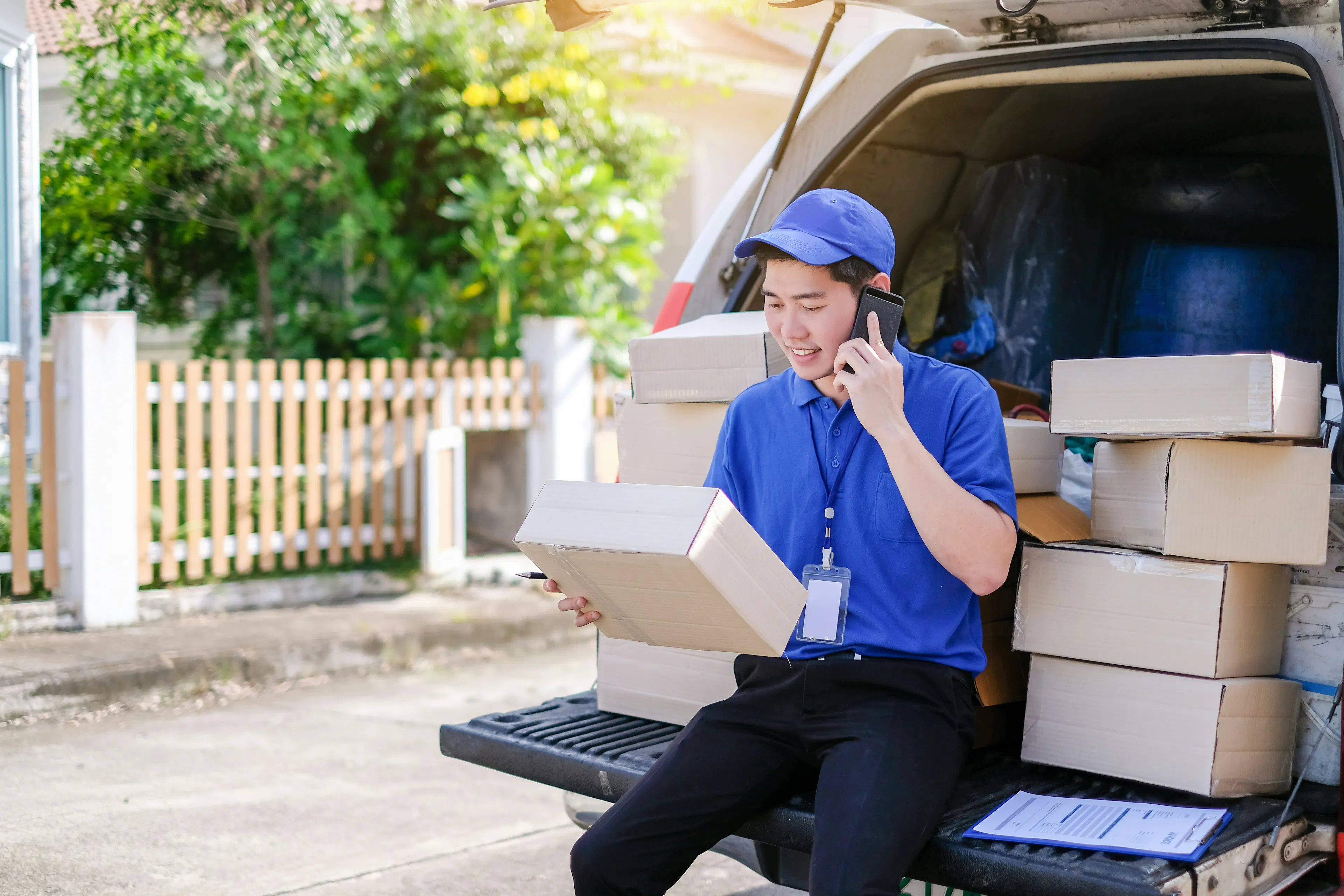 Delivery worker in blue uniform on phone call
