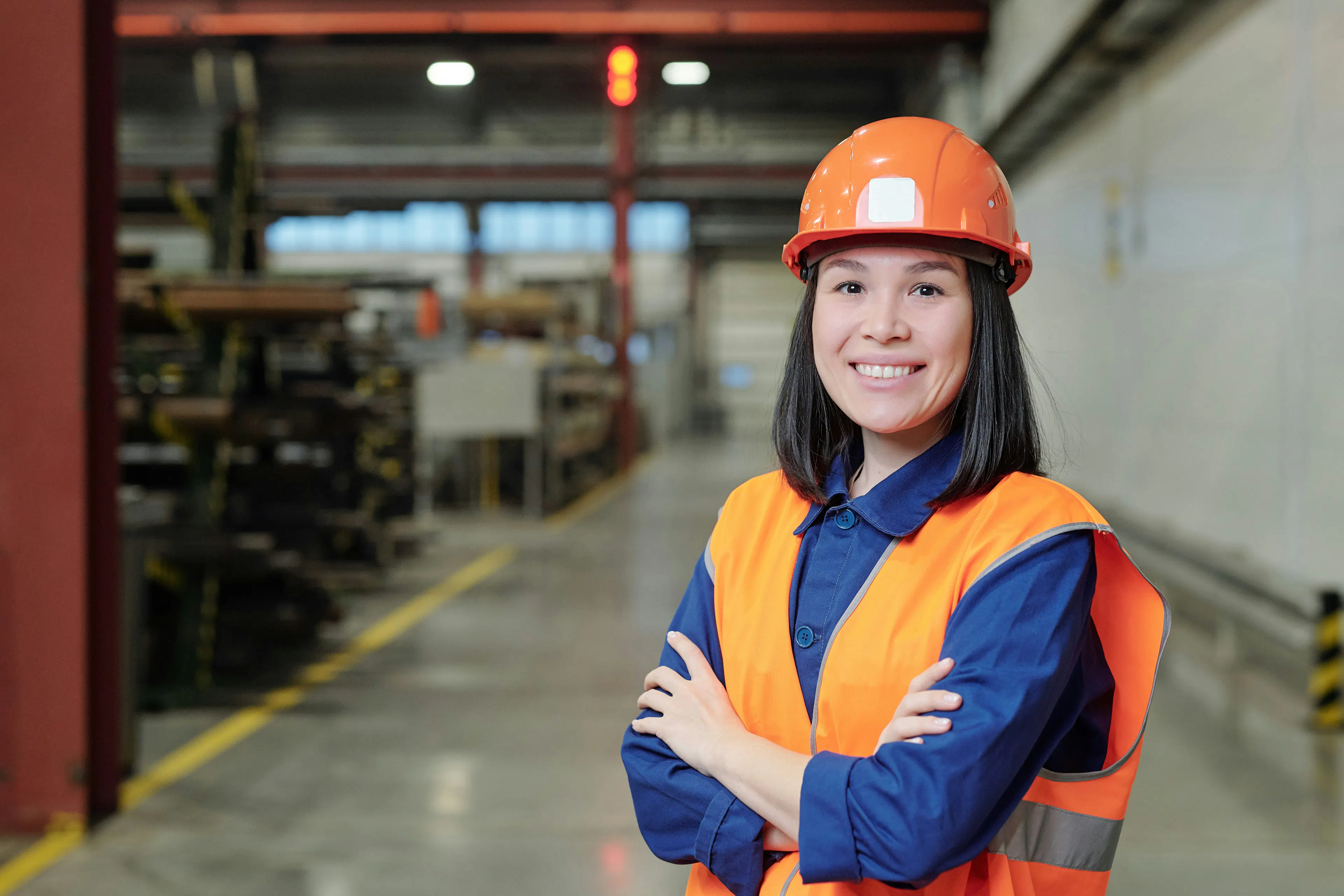 Smiling factory worker in a hard hat and safety vest