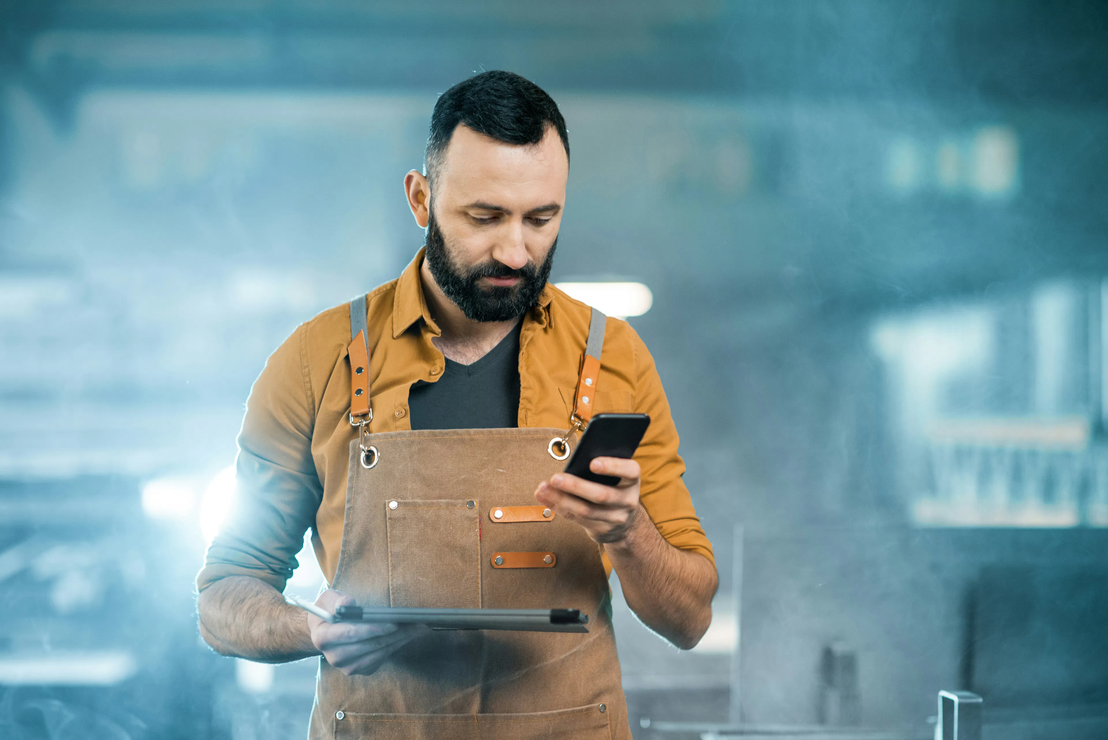 Frontline worker reading message on smartphone in workplace
