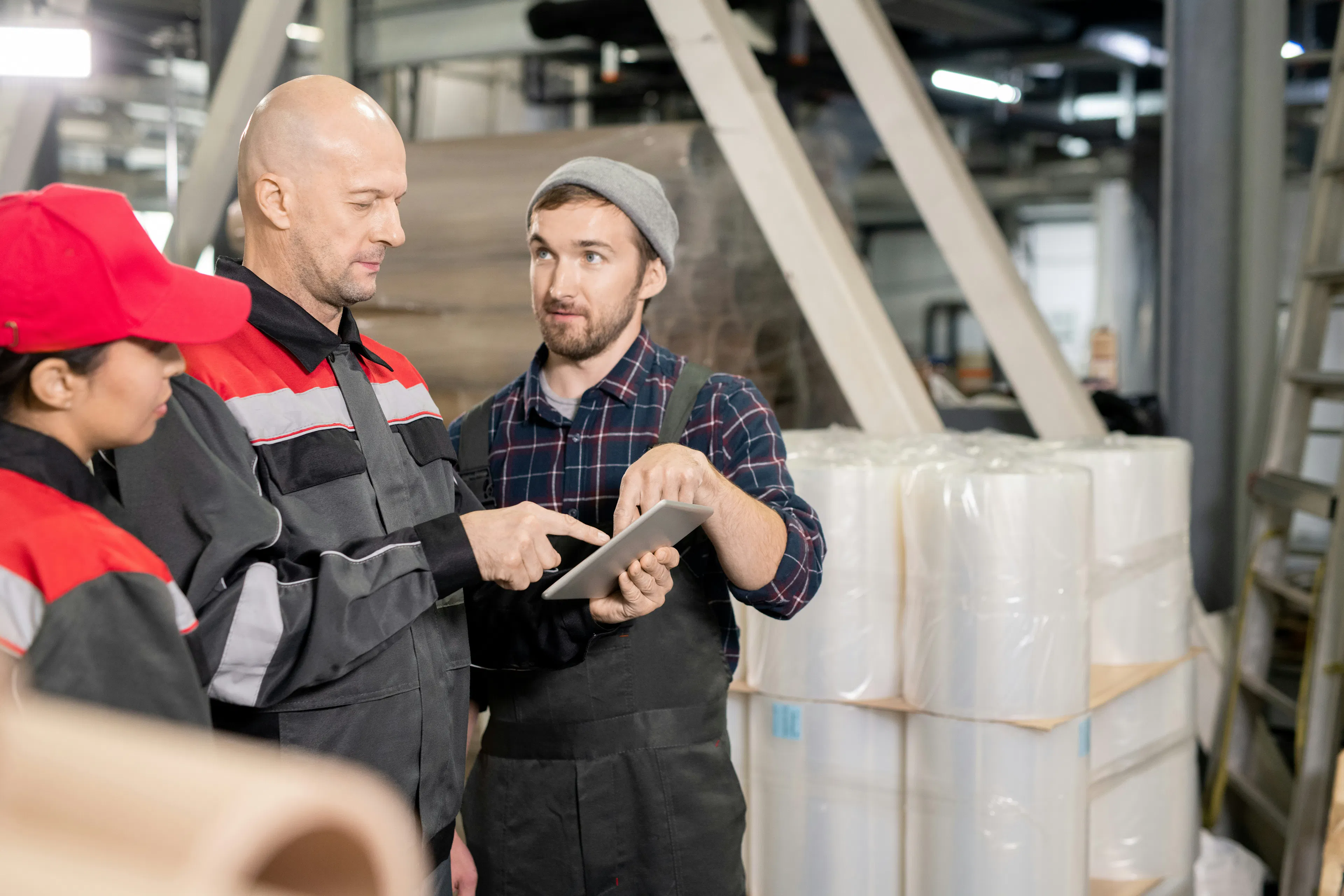 Frontline workers sharing feedback over tablet in factory