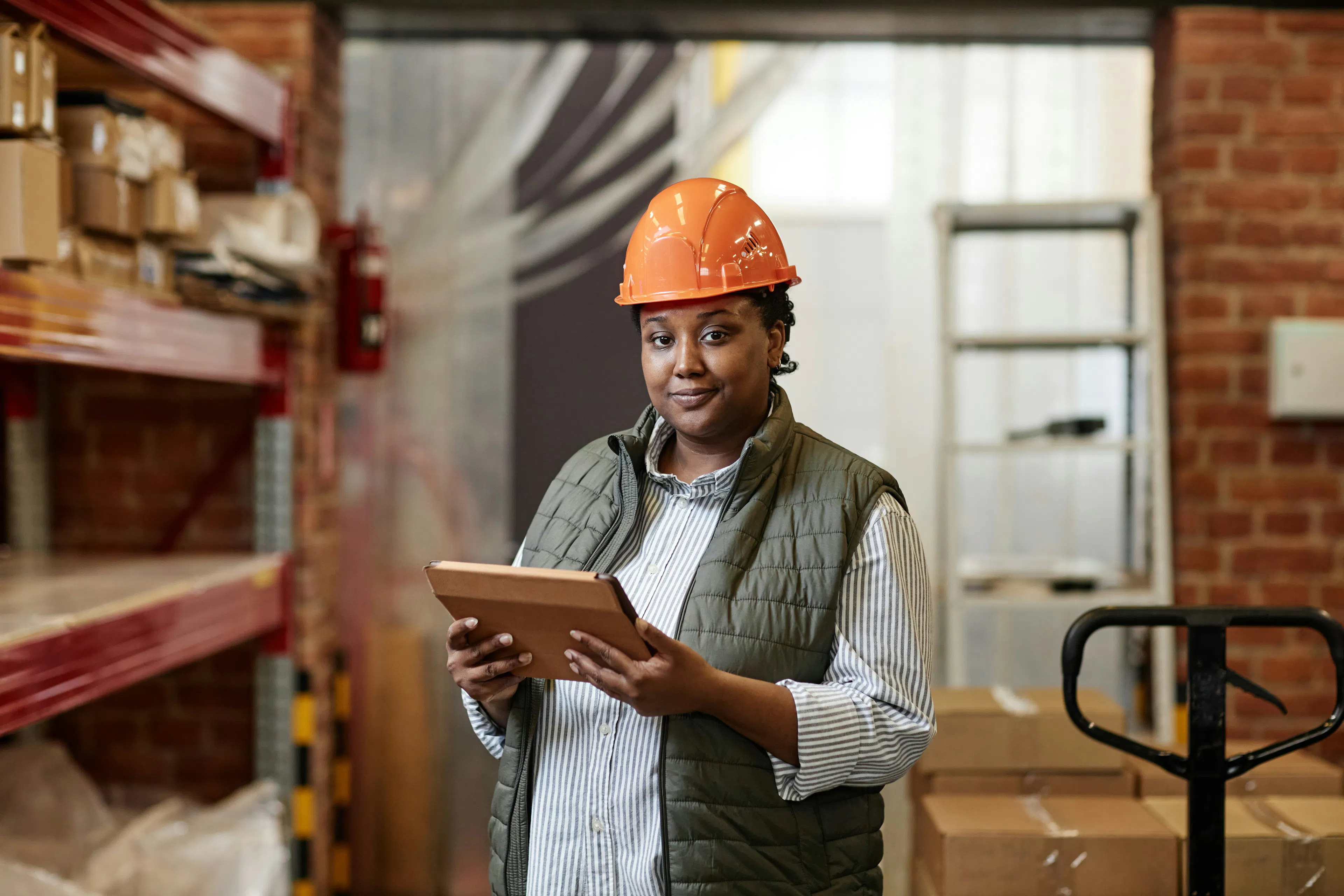 Frontline worker holding tablet in warehouse