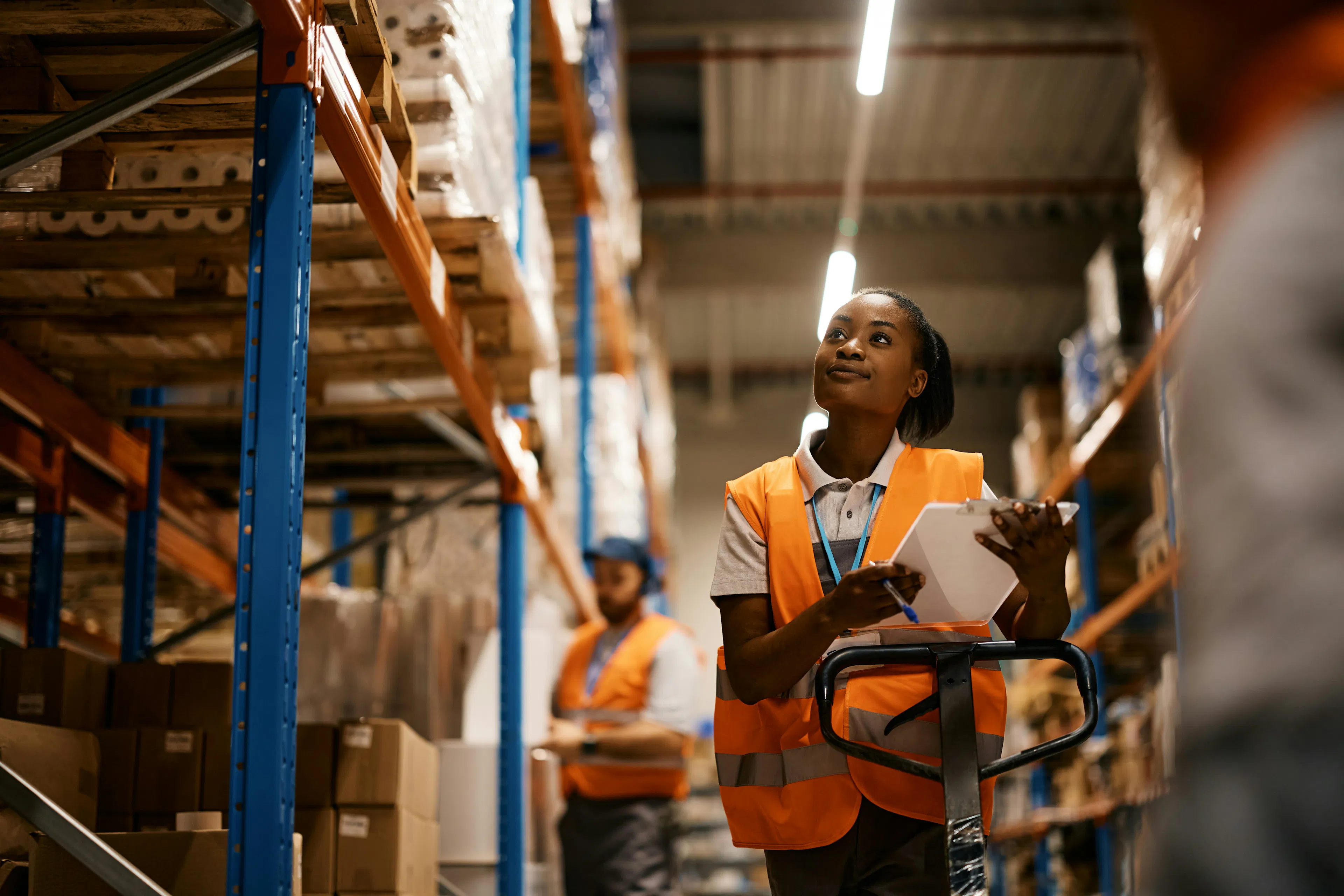 Warehouse worker in safety vest holding a tablet