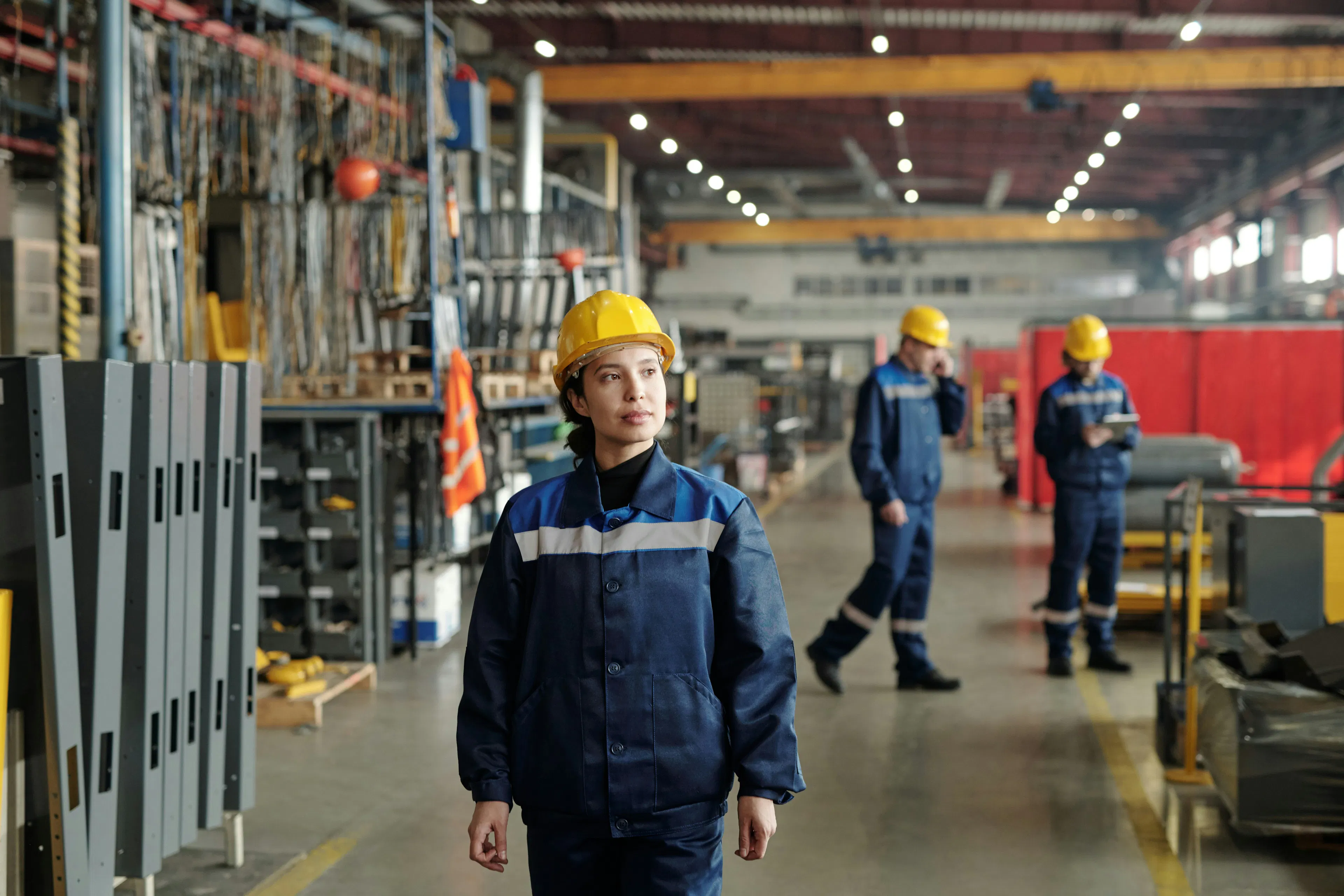 Manufacturing worker wearing hard hat on plant floor.