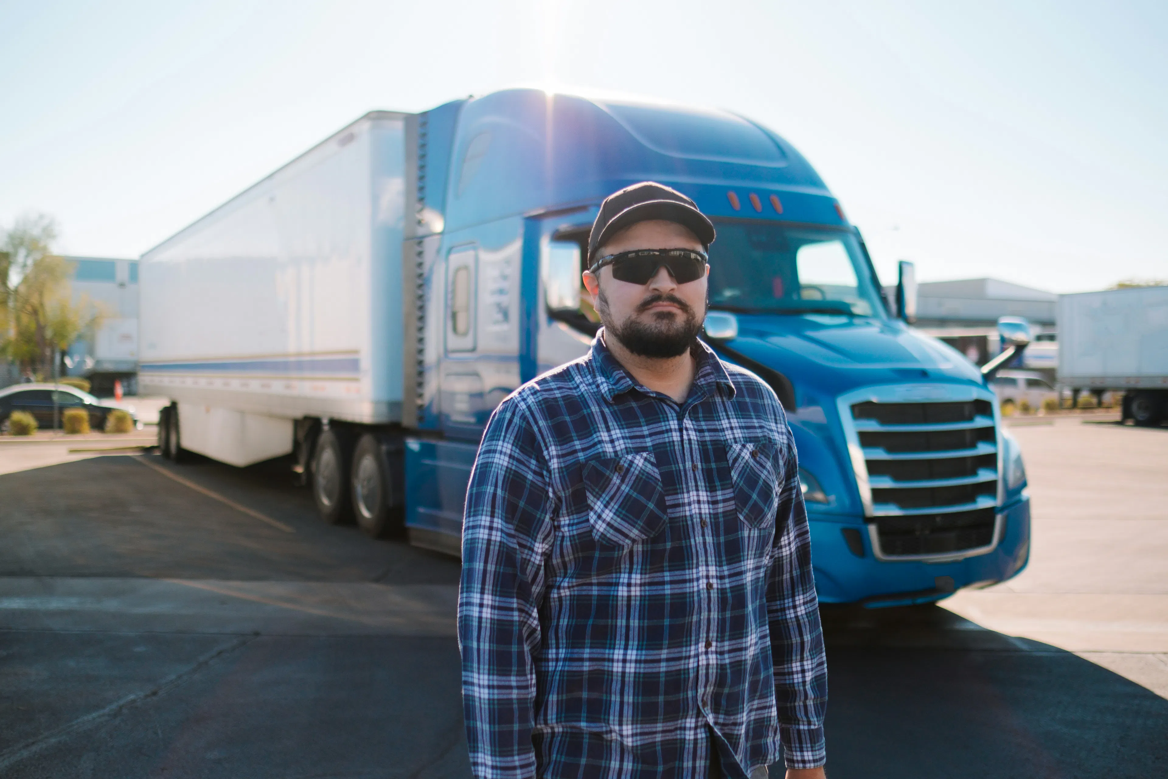 Truck driver standing in front of a semi truck
