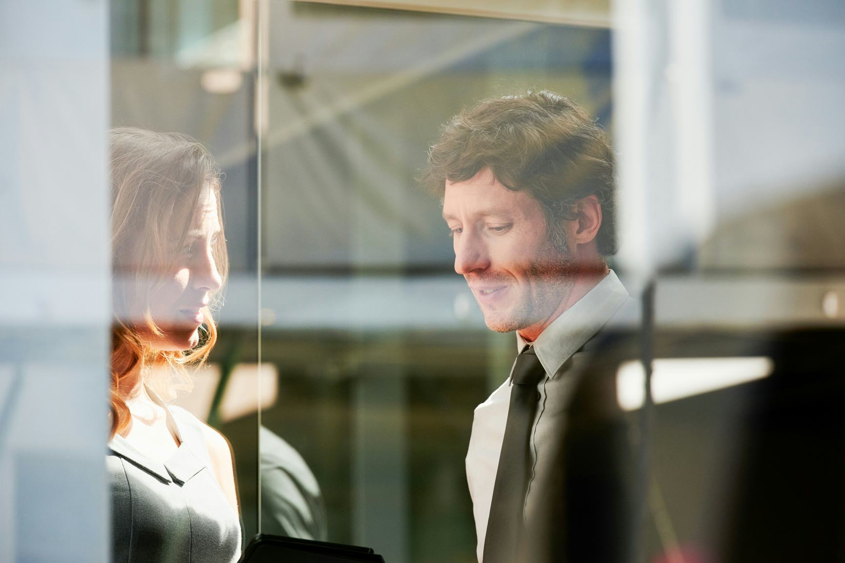 Two coworkers in suits in an office