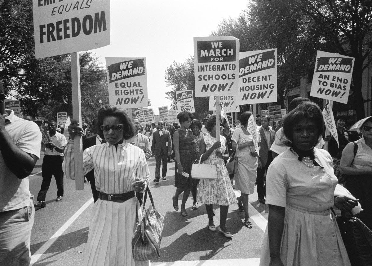 Une photo d'Afro-Américain·es manifestant pour l'égalité des droits, un logement décent et le droit de fréquenter des écoles réservées aux étudiants blancs.