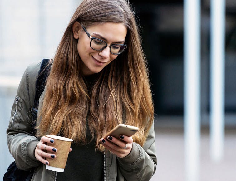 Woman looking at her phone to sign electronically