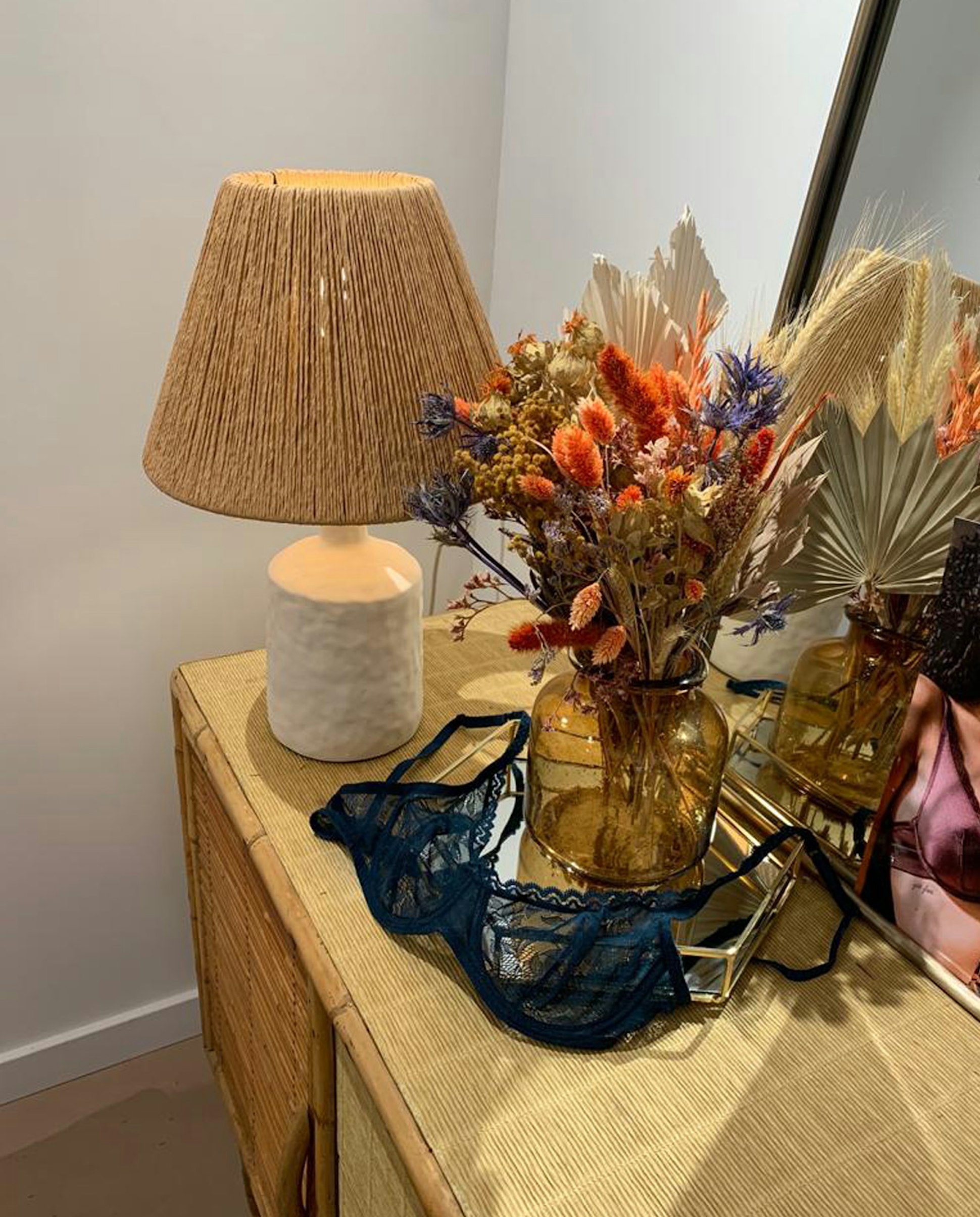 Nature morte bouquet de fleurs séchées et soutien-gorge corbeille bleu pétrole sur une commode dans la boutique Ysé de Bordeaux