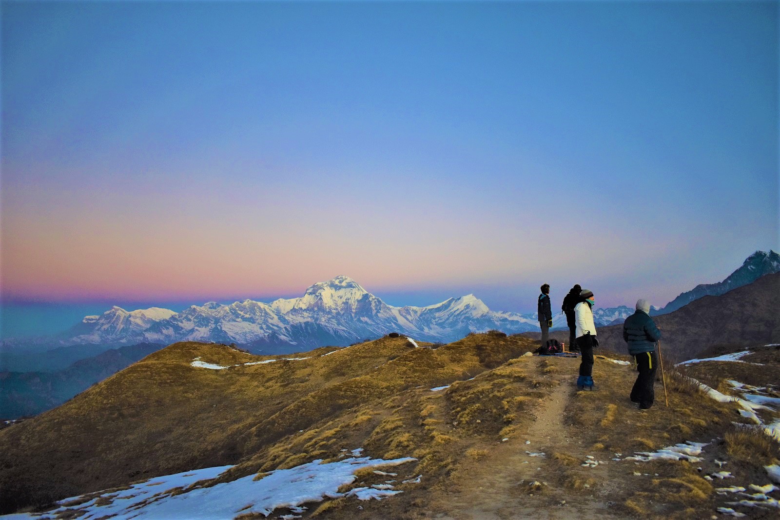 Trekkers stand atop Khopra Ridge in Nepal at sunrise.