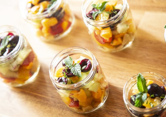Healthy breakfast fruit cups are served from mason jars at a yoga retreat in Portugal.
